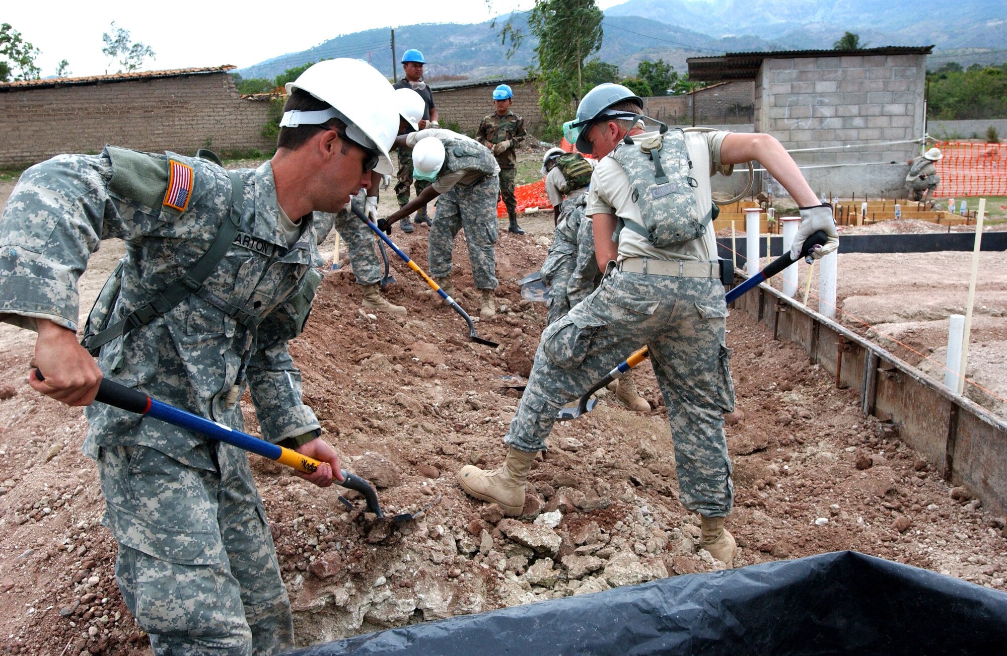 LA MERCED, HON - Soldiers from both the U.S. and Honduran armies work together shoveling dirt to place against framing before cement can be poured for the foundation of a new school here April 16. Photo by Staff Sgt. Danny McCormick, Beyond the Horizon Public Affairs.