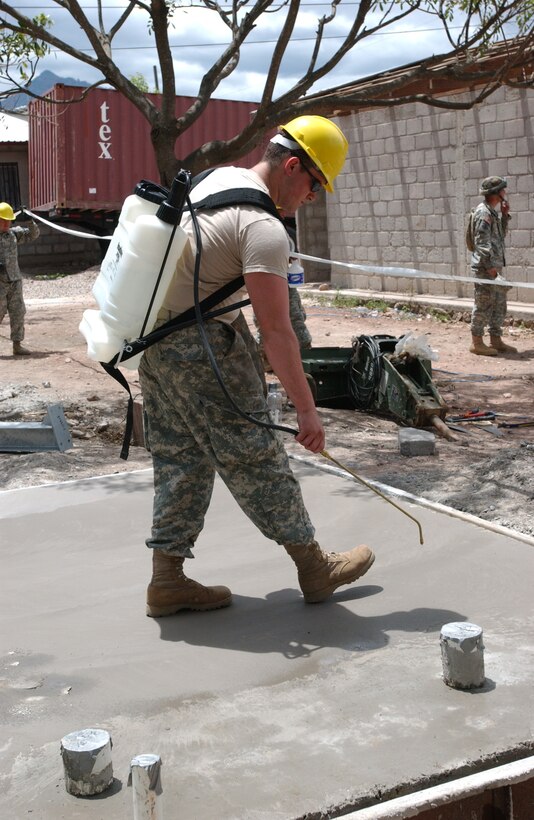 04/16/08 - LA GRANJA, HON - Army Reserve Soldier, Spc. Robert Magsamen sprays water onto a concrete slab to keep the concrete from drying too fast and cracking. The slab will provide  the base for a new school that the engineers are building. Magsamen is here with fellow 322nd Engineer Company Soldiers as part of the engineering exercise Beyond the Horizon 2008. Photo by Staff Sgt. Danny E. McCormick.