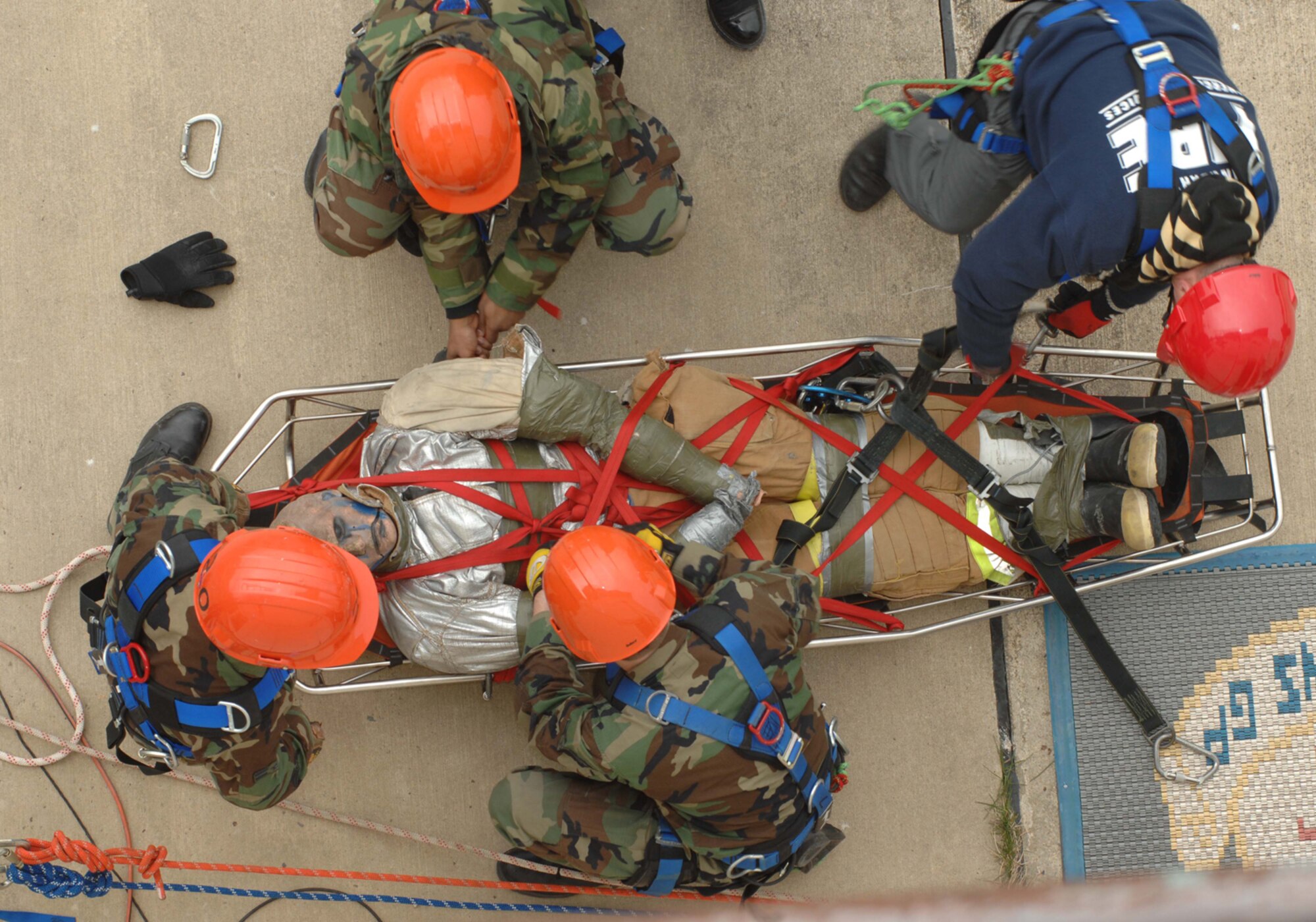 SPANGDAHLEM AIR BASE, Germany-- Airman First Class John Wright, Airman Jason Smith ,Airman First Class Martel Hunt and Herr Siegfried Mertiniet, 52nd Fire and Emergency Services Flight strap a simulated victim to a litter as part of a High Angle Rescue exercise April 18, 2008. The exercise is part of Rescue Technician Level 1 training that several of the firefighters received to enhance their ability to respond to emergencies. U.S. Air Force photo by Senior Airman Logan A. Tuttle. (Released)