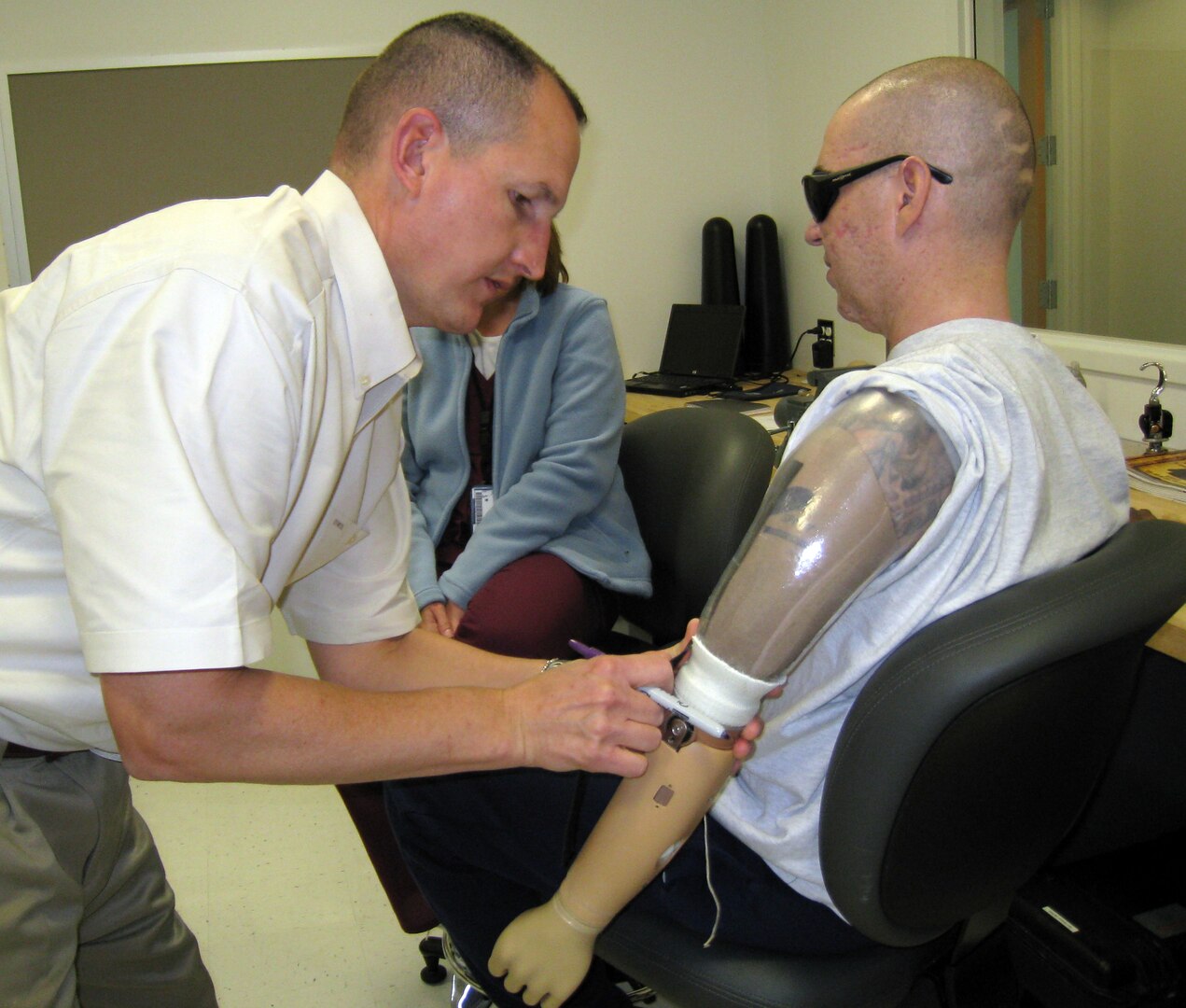 Del Lipe (left), a prosthetist, works to fit a prosthetic arm on Staff Sgt. Matthew Slaydon during his rehabilitation at Brooke Army Medical Center in San Antonio. (Courtesy photo)