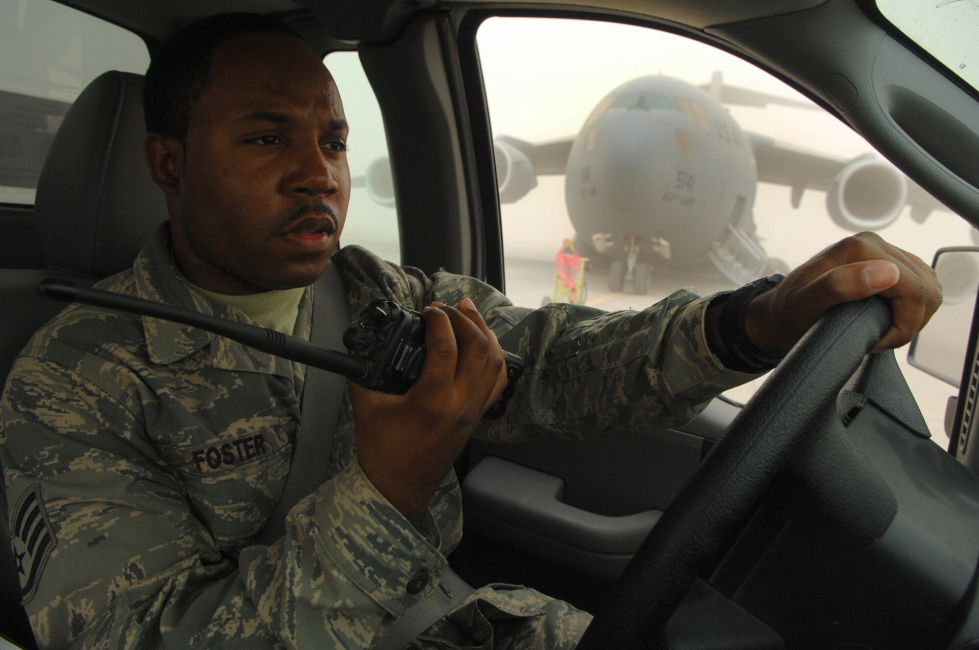 BALAD AIR BASE, Iraq -- Staff Sgt. DeShunn Foster, 332nd Expeditionary Operations Support Squadron airfield manager, calls in a sweeper team to clean up foreign object debris on the flightline during a dust storm here, April 29. Airfield managers ensure the airfield is free of hazards to aircraft and that safe operations are being conducted. Sergeant Foster is deployed from Seymour Johnson Air Force Base, N.C. (U.S. Air Force photo/ Senior Airman Julianne Showalter)