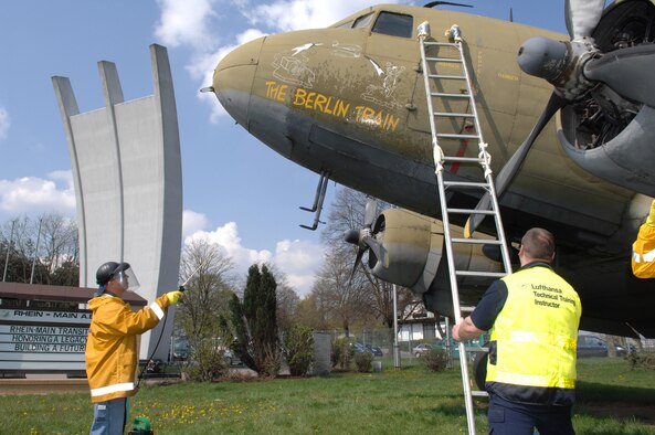 Air Force Staff Sgt. Kevin Cloyd, an aircraft maintenance crew chief, rinses the nose art on a static C-54 on display at the Berlin Airlift Memorial site of the former Rhein Main Air Base near Frankfurt International Airport in Germany. Cloyd and a team of approximately 30 volunteers from Ramstein Air Base spent three days cleaning the display aircraft for refurbishing in prepartion for a Berlin Airlift 60th Anniversary Celebration to take place there in June. (Department of Defense photo by Air Force Tech. Sgt. Corey Clements) 