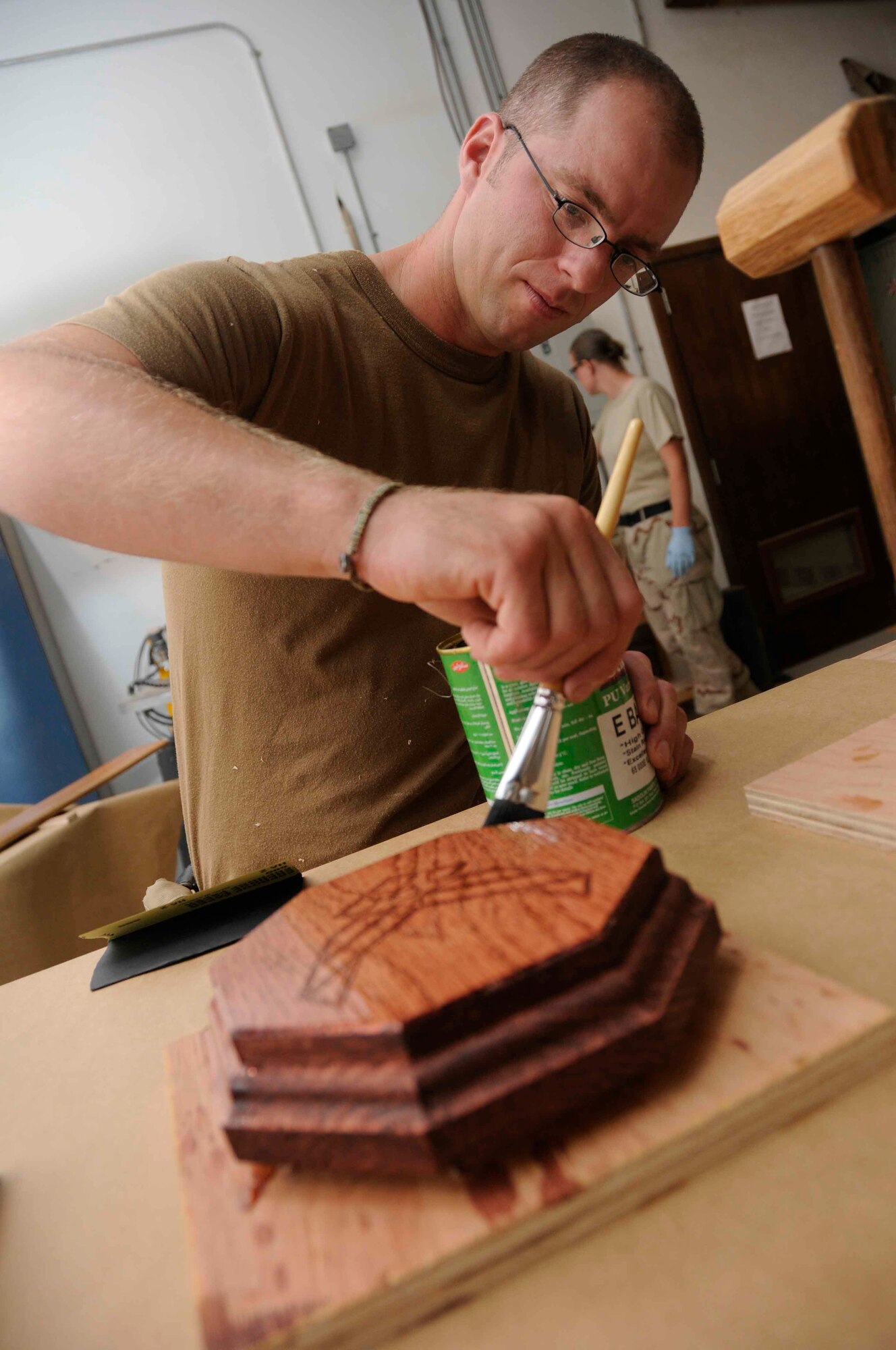 SOUTHWEST ASIA—Staff. Sgt. Jessie Butikofer, 379th Expeditionary Civil Engineer structures specialist, glazes a gavel block April 30.  The gavel and block combination is to be used for an upcoming Combat Dining Out. (U.S. Air Force photo/Senior Airman Domonique Simmons)