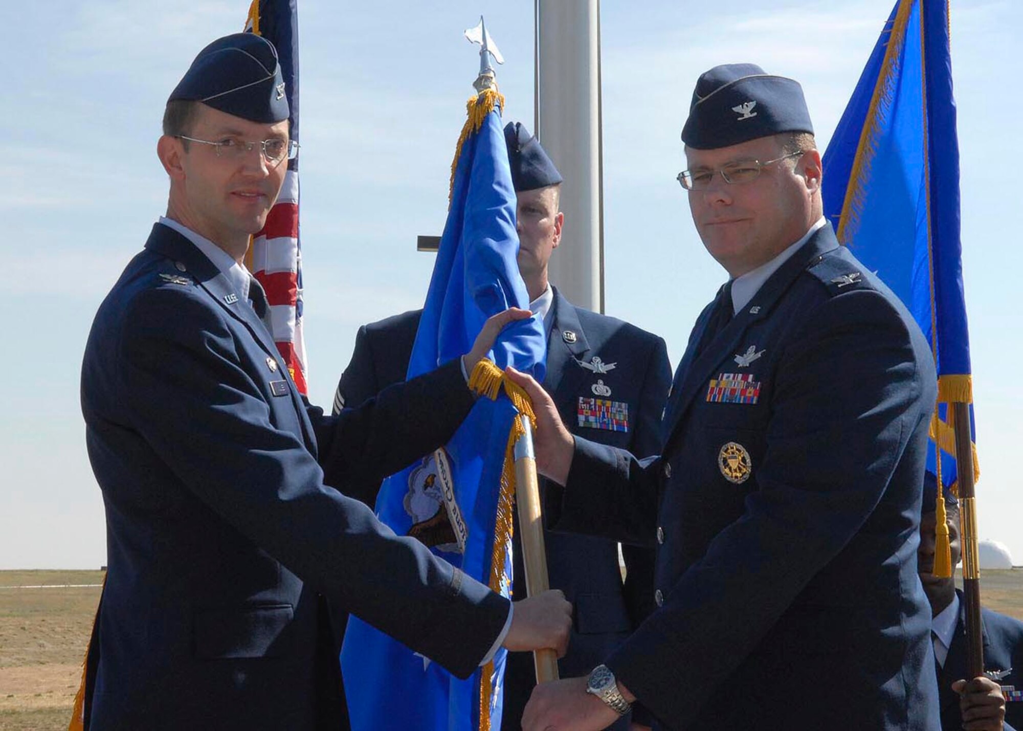 BUCKLEY AIR FORCE BASE, Colo -- Col. Wayne McGee, 460th Space Wing commander, passes the 460th Operations Group guidon -- during the group's change of command -- to Col. Richard Schoonmaker. Colonel Schoonmaker assumed command of the 460th OG April 30. (U.S. Air Force photo by Senior Airman Steve Czyz)
