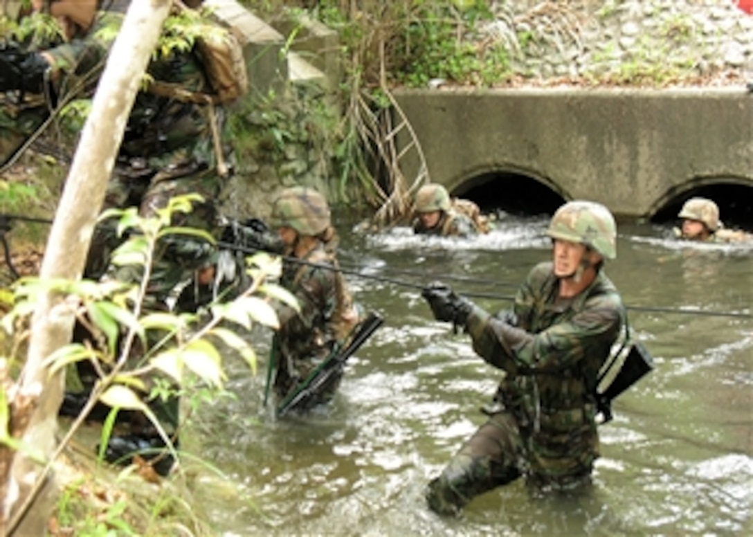 U.S. Navy Seabees assigned to Naval Mobile Construction Battalion 5 navigate the covert during a 3.4-mile endurance course at the Jungle Warfare Training Center on Camp Gonsalves in Japan on April 25, 2008.  The Seabees are taking part in a six-day training event designed to refine a unitís patrolling and combat skills in a jungle environment.  