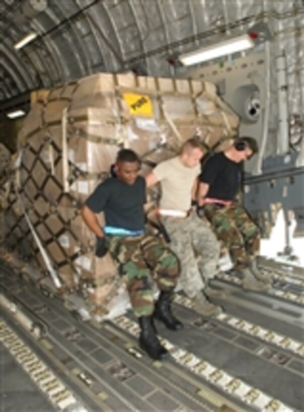 U.S. Air Force Tech. Sgt. Thomas Parker (left), with 46th Aerial Port Squadron, Airman 1st Class Brenten Chrans (center), with 436th Aerial Port Squadron, and Tech. Sgt. Randall Lemons (right), with 53rd Aerial Port Squadron, load pallets of cargo onto a C-17 Globemaster III aircraft at Dover Air Force Base, Del., on April 24, 2008.  