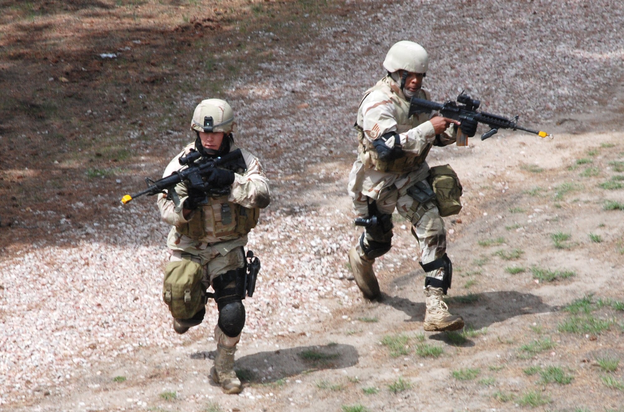 Staff Sgts. Brian Marshall (left) and Jordan Freeman rush a simulated enemy compound May 2 at the U.S. Air Force Academy, Colo. Both sergeants are members of the joint 21st/721st Security Forces Squadron Guardian Challenge team. The team competed against others throughout Air Force Space Command to determine which is the “best of the best” in defending installations and space assets world-wide. The six-man team is comprised of Tech. Sgt. Cesar Ochoa, Staff Sgts. Jordan Freeman, Brian Marshall and Jeffrey Turner, Senior Airman Eric Frias and Airman Stacy John. (U.S. Air Force photo/Senior Airman Stephen Collier)