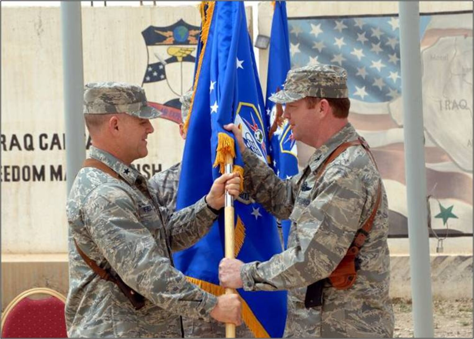KIRKUK REGIONAL AIR BASE, Iraq -- Col. Richard Scobee accepts command of the 506th Air Expeditionary Group from Brig. Gen. Burton Field, 332nd Air Expeditionary Wing commander, April 30, here. Colonel Scobee is the 944th Fighter Wing commander, Luke Air Force Base, Ariz. (U.S. Air Force photo/Senior Airman SerMae Lampkin)