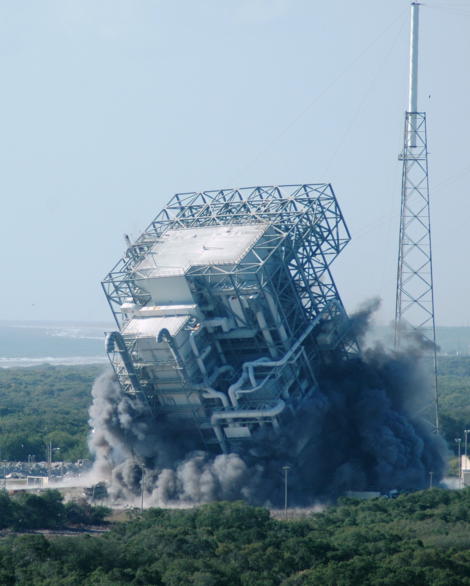 The mobile service tower at Space Launch Complex 40 raises a cloud of dust and smoke as it falls to the ground at Cape Canaveral Air Force Station April 27. The obsolete tower was demolished to make way for new launch programs at Cape Canaveral. (U.S. Air Force photo by Airman 1st Class David Dobrydney)