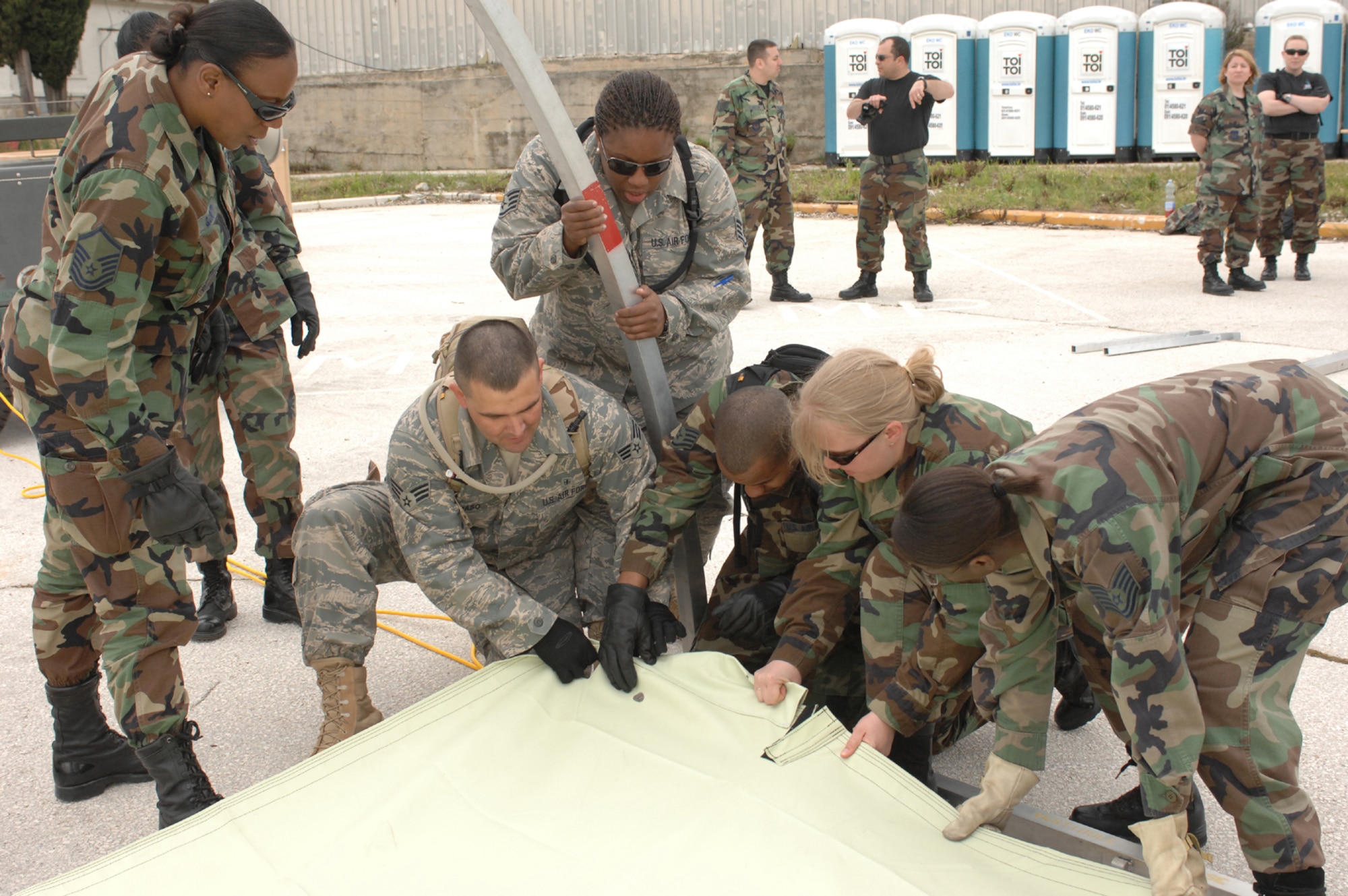 DIVULJE TRAINING BASE, Croatia – U.S. Air Force medical personnel join together to learn how to assemble tents April 30.  The tents are Expeditionary Medical Squadron (EMEDS) +10 tents designed to provide patient care for ten or more people as a mobile field hospital.  Members of this team are deployed from Spangdahlem Air Base, Ramstein Air Base and Landstuhl Regional Medical Center, all in Germany, for the 2008 Medical Training Exercise in Central and Eastern Europe (MEDCEUR).  Fifteen nations are participating in the exercise from May 2 through 14. The exercise focuses on mass-casualty training scenarios and humanitarian aid in response to crises situations. More than 400 multi-nationals are attending the exercise in support of the Partnership for Peace initiative. (U.S. Air Force photo/Staff Sgt. Kristin Ruleau) 