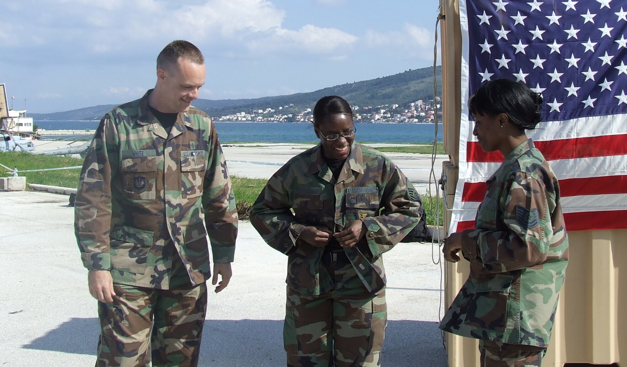 DIVULJE TRAINING BASE, Croatia – Lt. Col. Jeffrey White and Tech. Sgt. Yoketha Parker watch while Master Sgt. Janet Woodard puts on her Battle Dress Uniform with her master sergeant stripes April 30. The U.S. Air Force Airmen are deployed to the 458th Expeditionary Medical Squadron from Ramstein Air Base, Germany, to participate in Medical Training Exercise in Central and Eastern Europe 2008 (MEDCEUR 08). Fifteen nations are participating in the exercise May 2 through 14. The exercise focuses on mass-casualty training scenarios and humanitarian aid in response to crises situations. More than 400 multi-nationals are attending the exercise in support of the Partnership for Peace initiative. (U.S. Air Force photo/Chaplain (Capt.) Gabriel Rios)