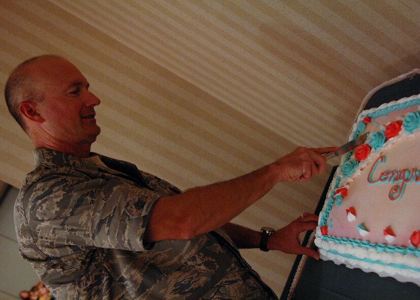 MOODY AIR FORCE BASE, Ga. -- Col. Les Martin, commander of the 23rd Mission Support Group, cuts a cake during the Moody Spouse's Club scholarship banquet here May 1. Sixteen Moody spouses and dependents were selected to receive scholarships of up to 1,000 dollars. (U.S. Air Force photo by Airman 1st Class Brittany Barker)