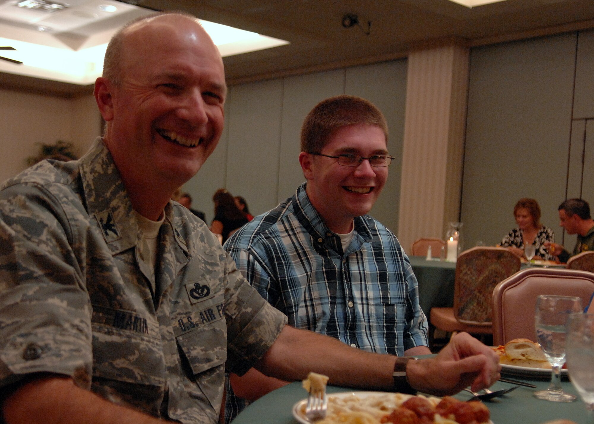 MOODY AIR FORCE BASE, Ga. -- Col. Les Martin, commander of the 23rd Mission Support Group, laughs while eating dinner with his sponsoree Drew Martin during the Moody Spouse's Club scholarship banquet here May 1. Sixteen Moody spouses and dependents were selected to receive scholarships of up to 1,000 dollars. (U.S. Air Force photo by Airman 1st Class Brittany Barker)