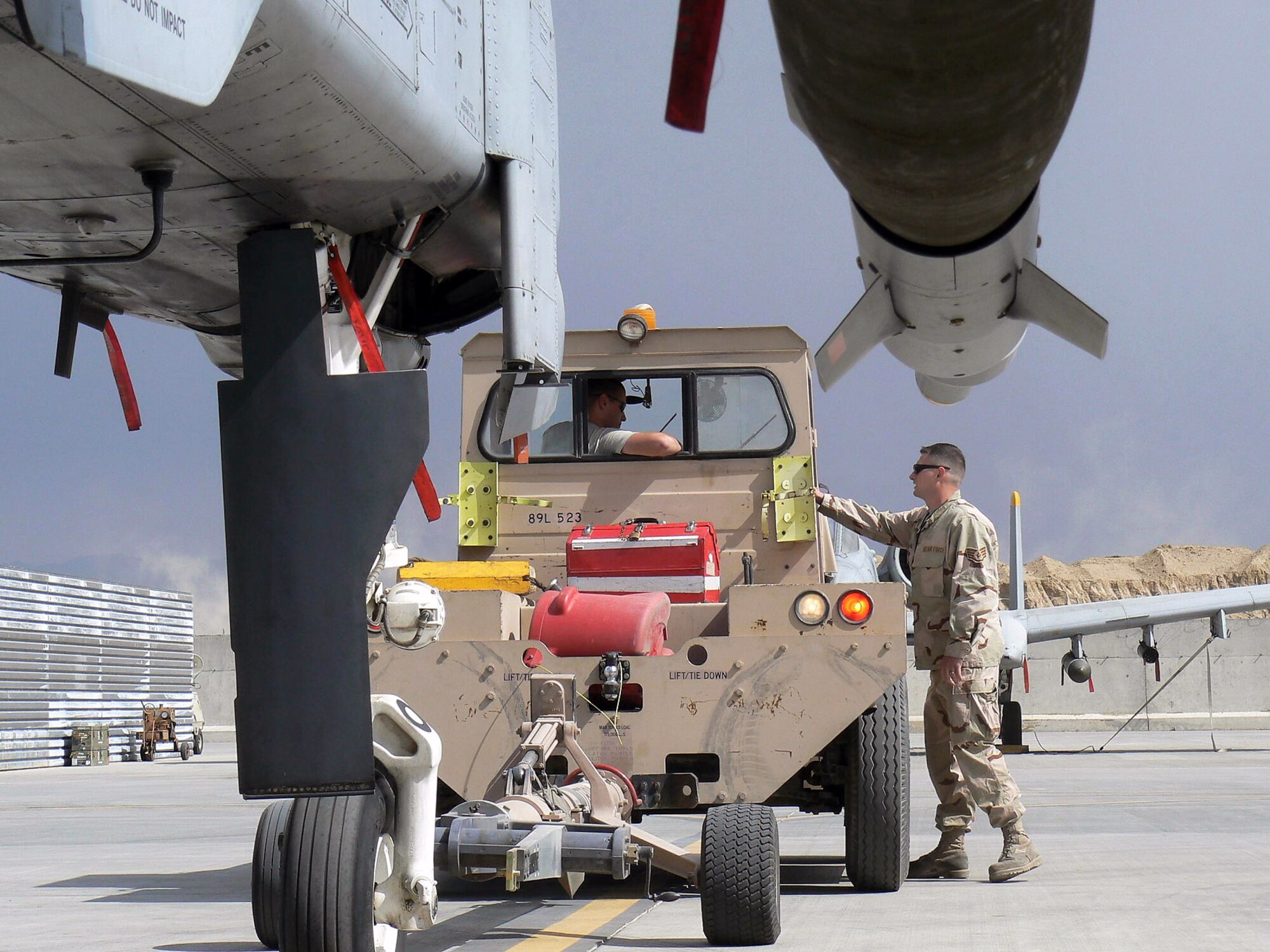 Senior Airman Tristan Bacom tows an A-10 Thunderbolt II at Bagram Air Base, Afghanistan, while Staff Sgt. Damon Ballard supervises the operation. Both crew chiefs are assigned to the 81st Expeditionary Aircraft Maintenance Unit and are deployed from Spangdahlem Air Base, Germany. (U.S. Air Force photo by Senior Airman Eric Gibson)