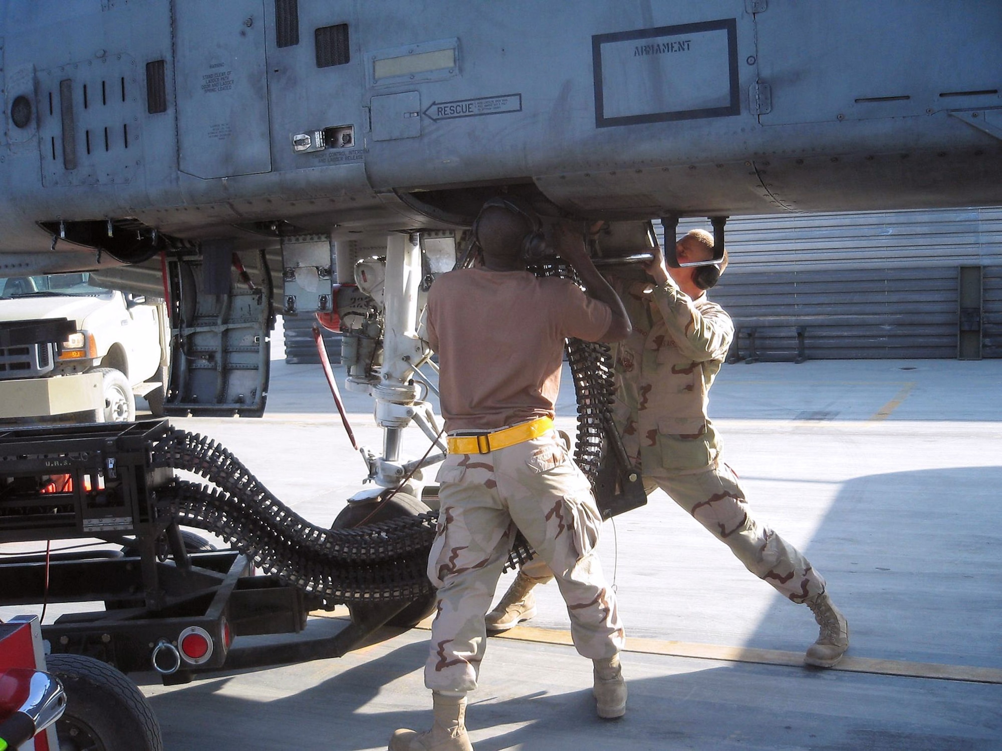 Staff Sgt. Jakonise Jones (left) and Airman Nicholas Giacomino connect an ammunition loading adaptor to the gun system of an A-10 Thunderbolt II at Bagram Air Base, Afghanistan.  They are preparing to reload the aircraft with 30 mm ammunition. The Airmen, assigned to the 81st Expeditionary Aircraft Maintenance Unit, are both deployed from Spangdahlem Air Base, Germany. (U.S. Air Force photo by 1st Lt. Kristen Lainis)