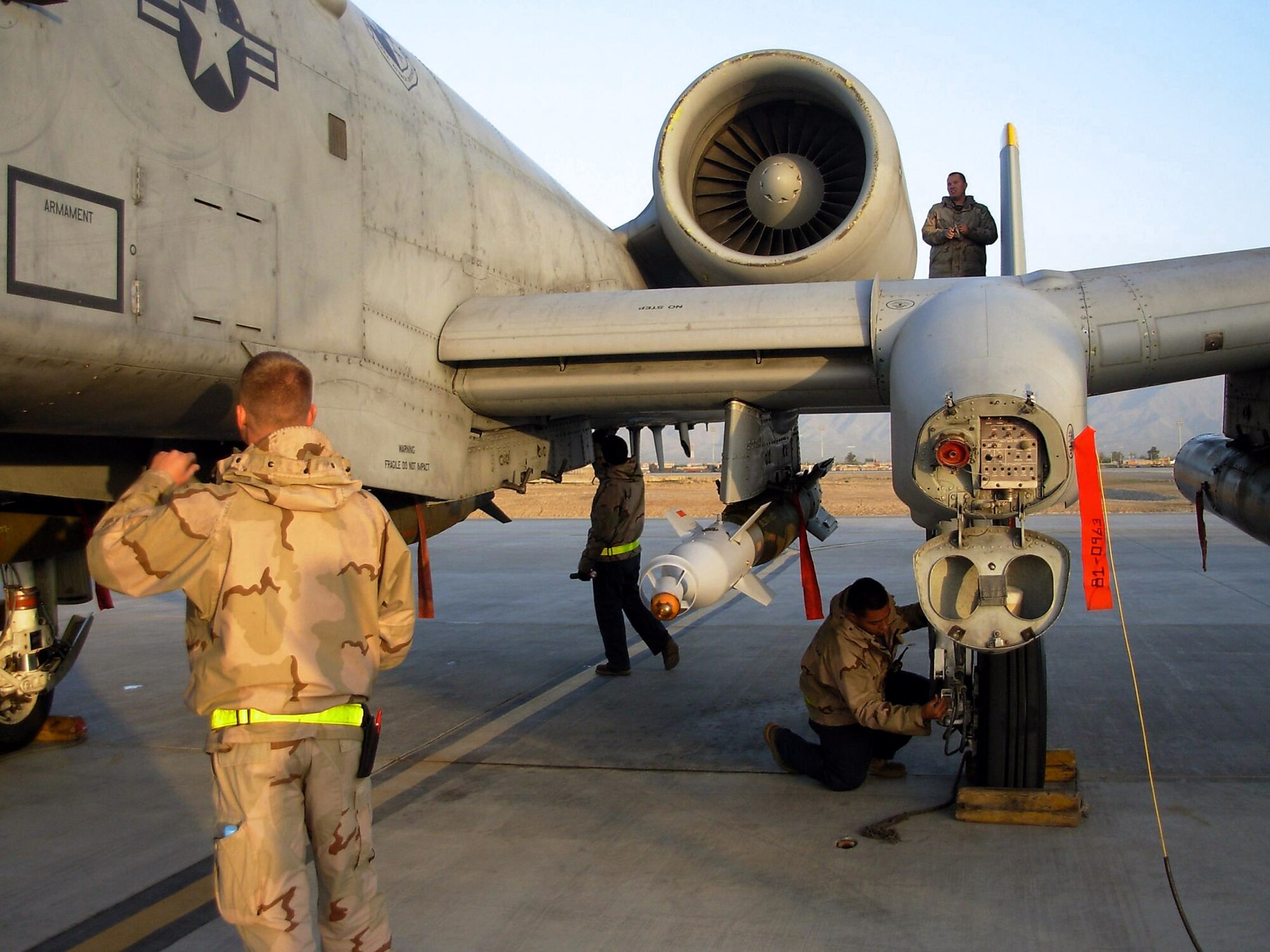During a thru-flight inspection of an A-10 Thunderbolt II at Bagram Air Base, Afghanistan, Senior Airmen Justin Lovejoy (left) and Mike Pena (center) examine the fuselage while Staff Sgt. Isaac Ibarra inspects the breaks. Up on the wing, Staff Sgt. Shawn Mercier performs an intake and exhaust inspection on the aircraft's engine. The crew chiefs, assigned to the 81st Expeditionary Aircraft Maintenance Unit, are deployed from Spangdahlem Air Base, Germany. (U.S. Air Force photo by Master Sgt. Tom Bivens)
