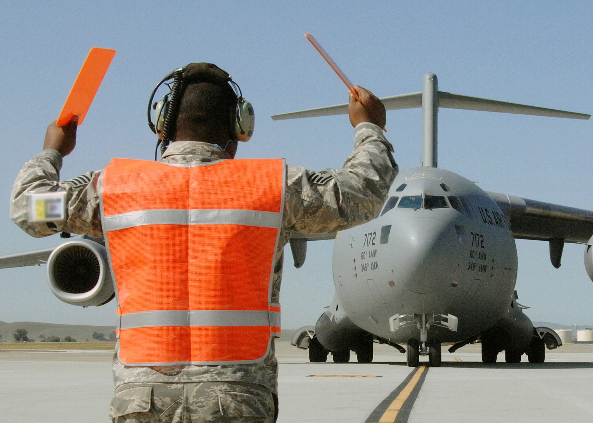 Staff Sgt. Bernard Thomas, 860th Aircraft Maintenance Squadron, marshals in the 60th Air Mobility Wing's newest C-17. Brig. Gen. Mark Solo, Air Mobility Command's Deputy Director of Air, Space and Information Operations, delivered the new aircraft to Travis Air Force Base, Calif. The C-17, tail number 77172, is the twelfth of 13 C-17s to be based there. (U.S. Air Force photo/David W. Cushman)