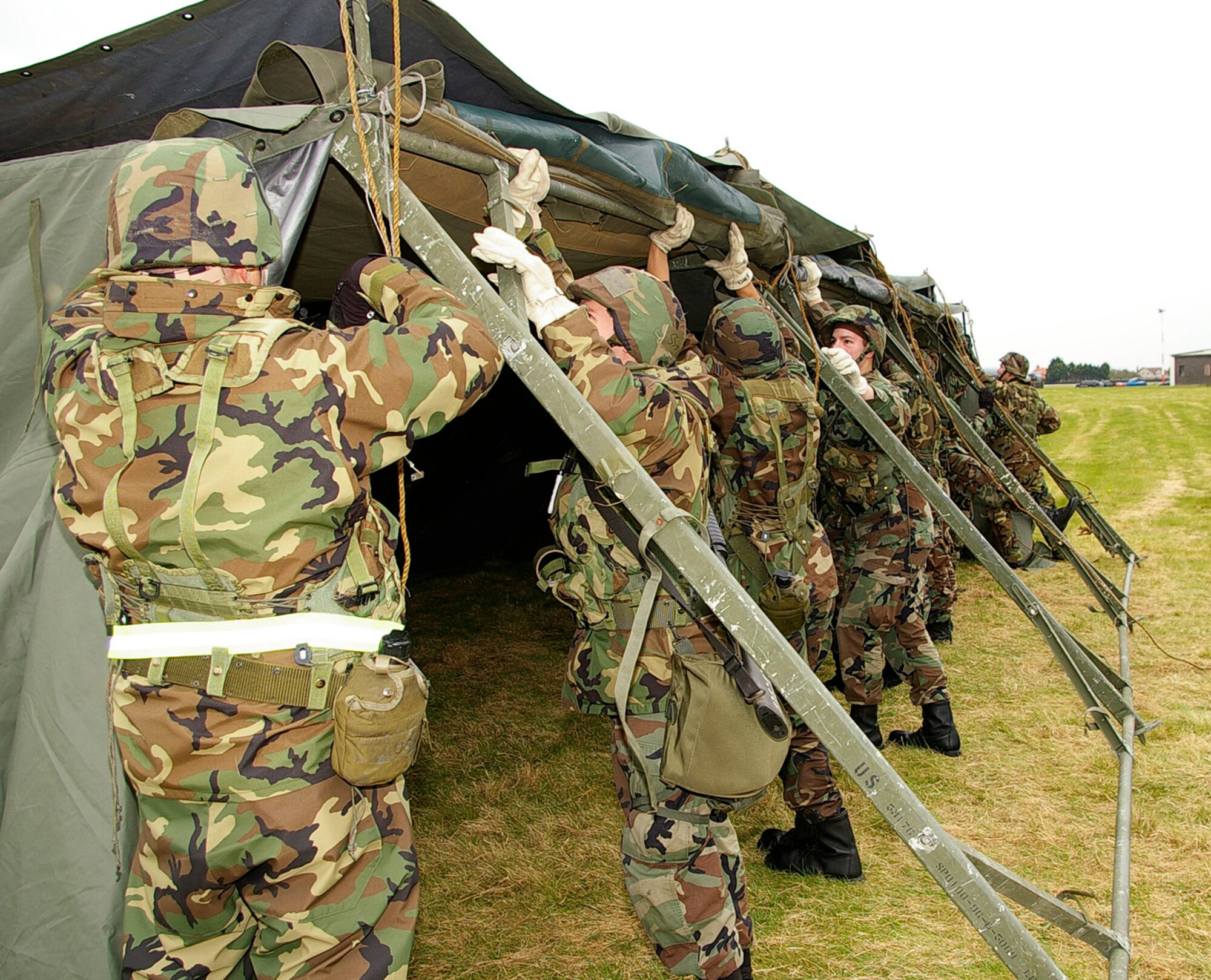 Personnel from the 100th Civil Engineer Squadron and 48th Civil Engineer Squadron work together to put up tents at the field training exercise on the south side of base April 24. (U.S. Air Force photo by Karen Abeyasekere)