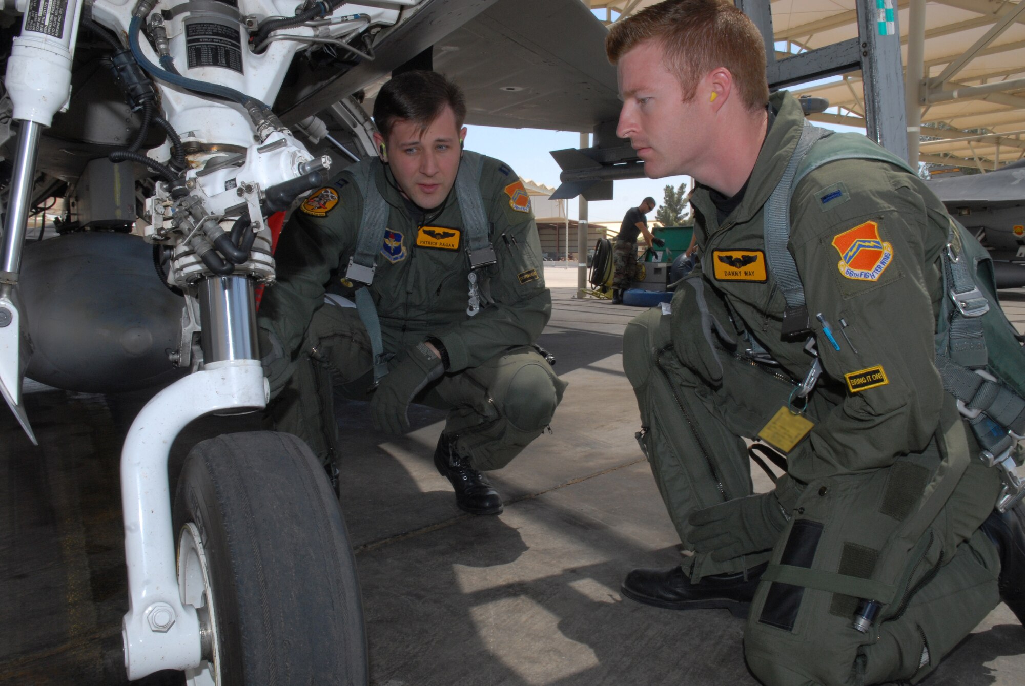 1st Lieutenant Danny May, a 61st Fighter Squadron student pilot, and Captain Patrick Ragan, a 61st FS instructor pilot, perform their flight pre-checks on an F-16, Apr. 29, Luke Air Force Base, Ariz. This is Lt. May's first time flying an F-16. (U.S. Air Force photo/Airman 1st Class Gustavo Gonzalez)