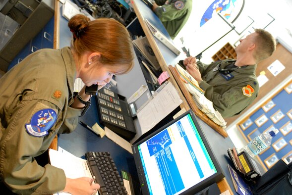 Maj. Gina Sabric, 309th Fighter Squadron assistant director of operations, takes a phone call before giving a step brief, Apr. 28. Step briefs include information on airfield status,weather updates, current operational risk management issues and is when the pilot sign out their jet. (U.S. Air Force photo/Staff Sergeant Christopher Hummel)