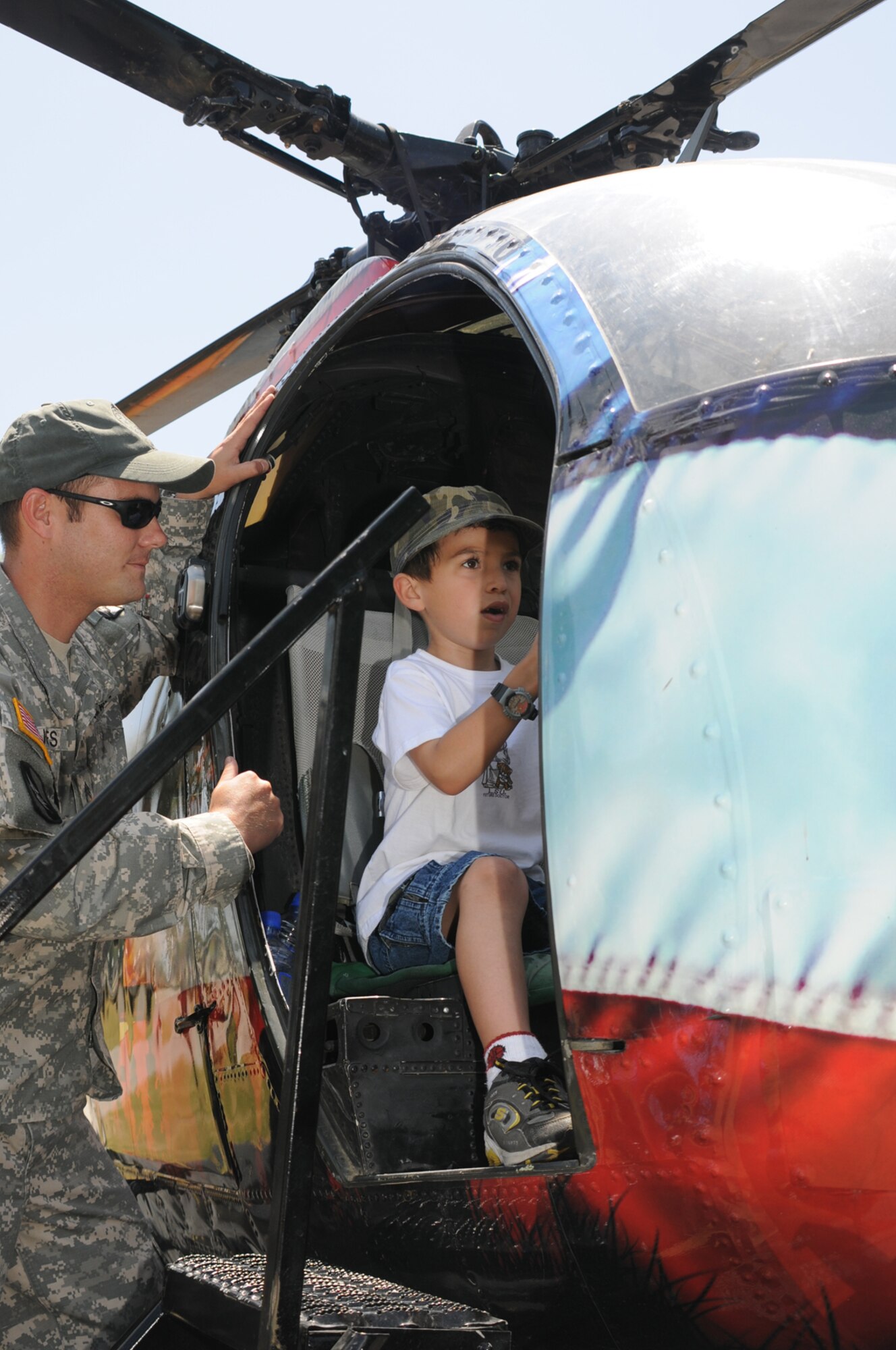 Army National Guard Staff Sgt. Justin Jones shows an OH-6 helicopter to Alfonso Vargas IV, 6, son of Maj. Alfonso and Bethsy Vargas, 81st Medical Group.  (U.S. Air Force photo by Kemberly Groue)