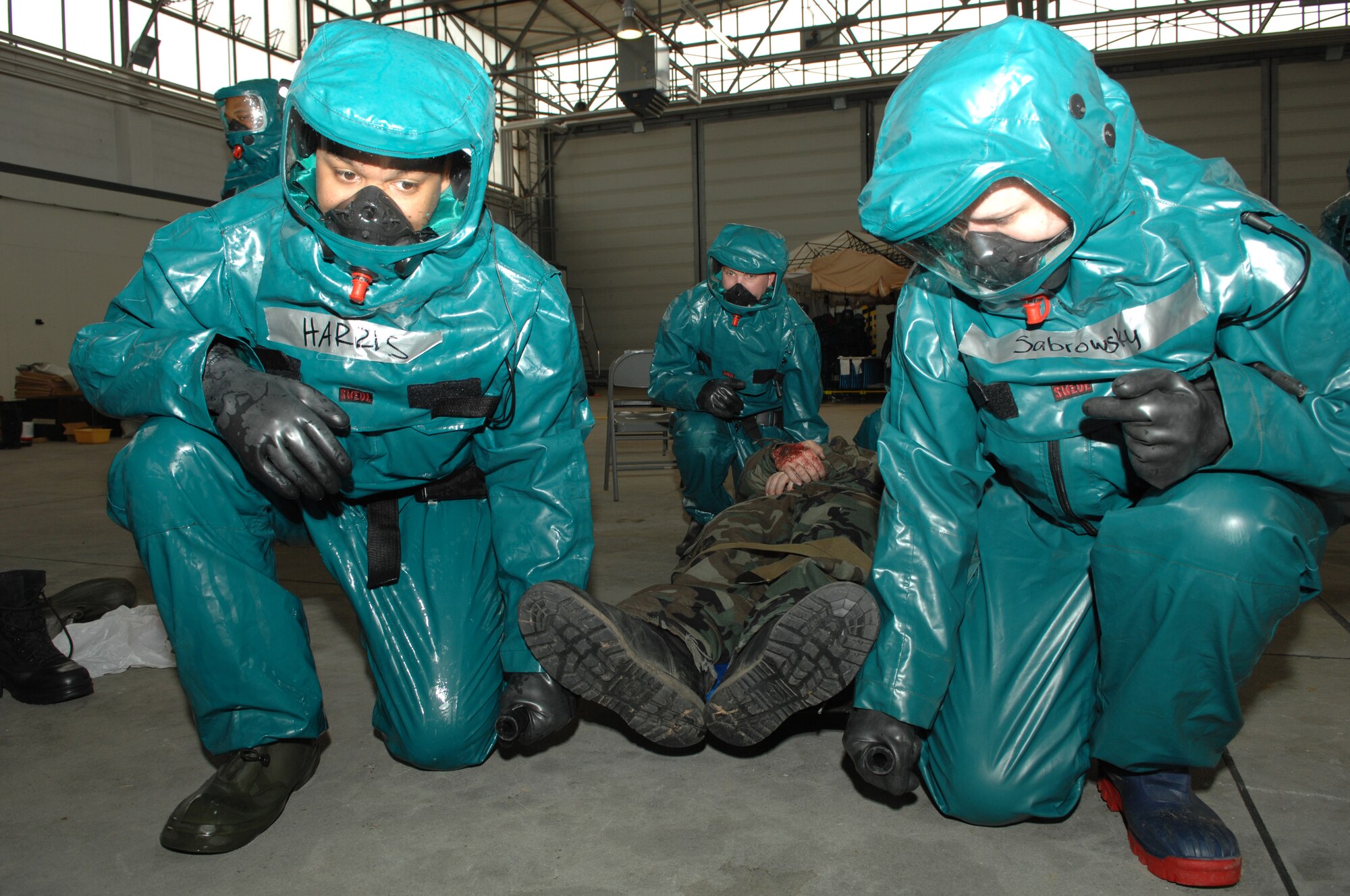 Senior Airman Armando Harris and Senior Airman Stacey Sabrowsky prepare to lift a moulage patient for processing through the decontamination tent as part of exercise Saber Crown 08-06 at Spangdahlem AB, Germany, on April 23, 2008. (U.S. Air Force Photo/Staff Sergeant Heather M. Norris)
