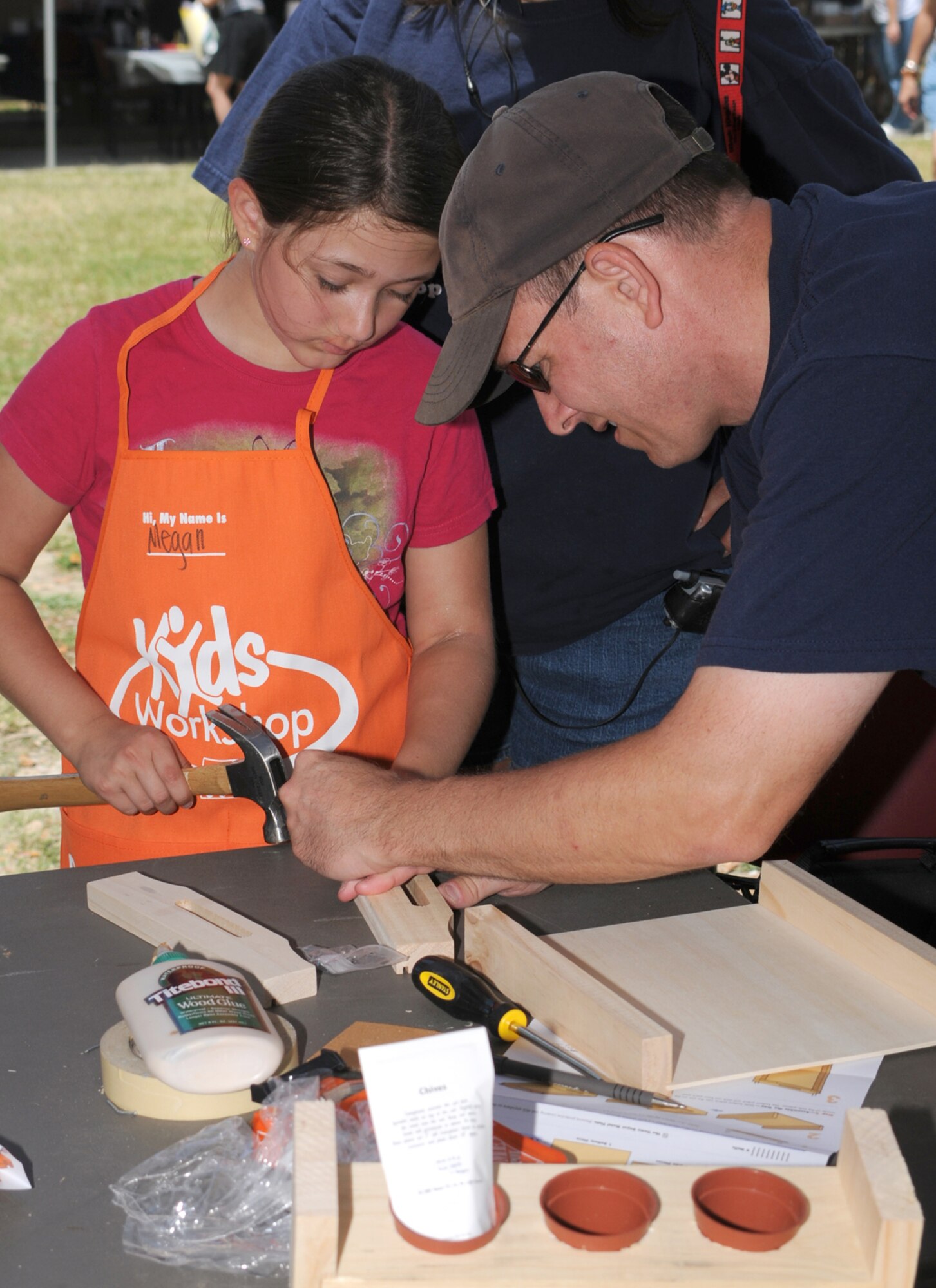 Megan Donnett, 8, and her dad, Keesler Fire Chief J.D. Donnett, tackle a woodworking project at the Home Depot booth.  (U.S. Air Force photo by Kemberly Groue)