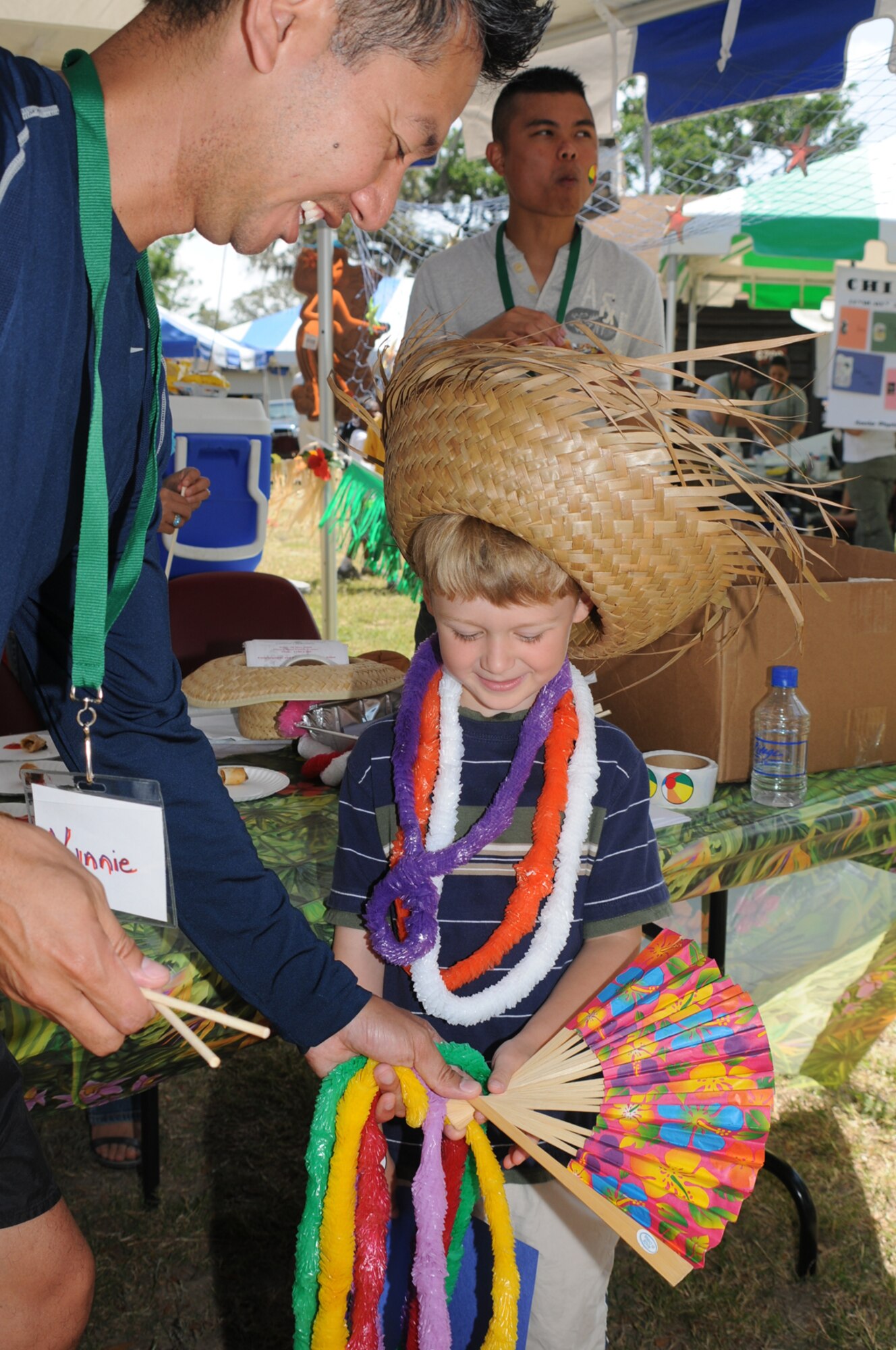 Nelson Viniegra, 81st Medical Operations Squadron, introduces 5-year-old Will Marts to items at the Asian-Pacific American Heritage Committee’s booth Saturday in marina park.  Will’s parents are Capt. Sean and Jackie Marts, 81st Inpatient Operations Squadron.  (U.S. Air Force photo by Kemberly Groue)