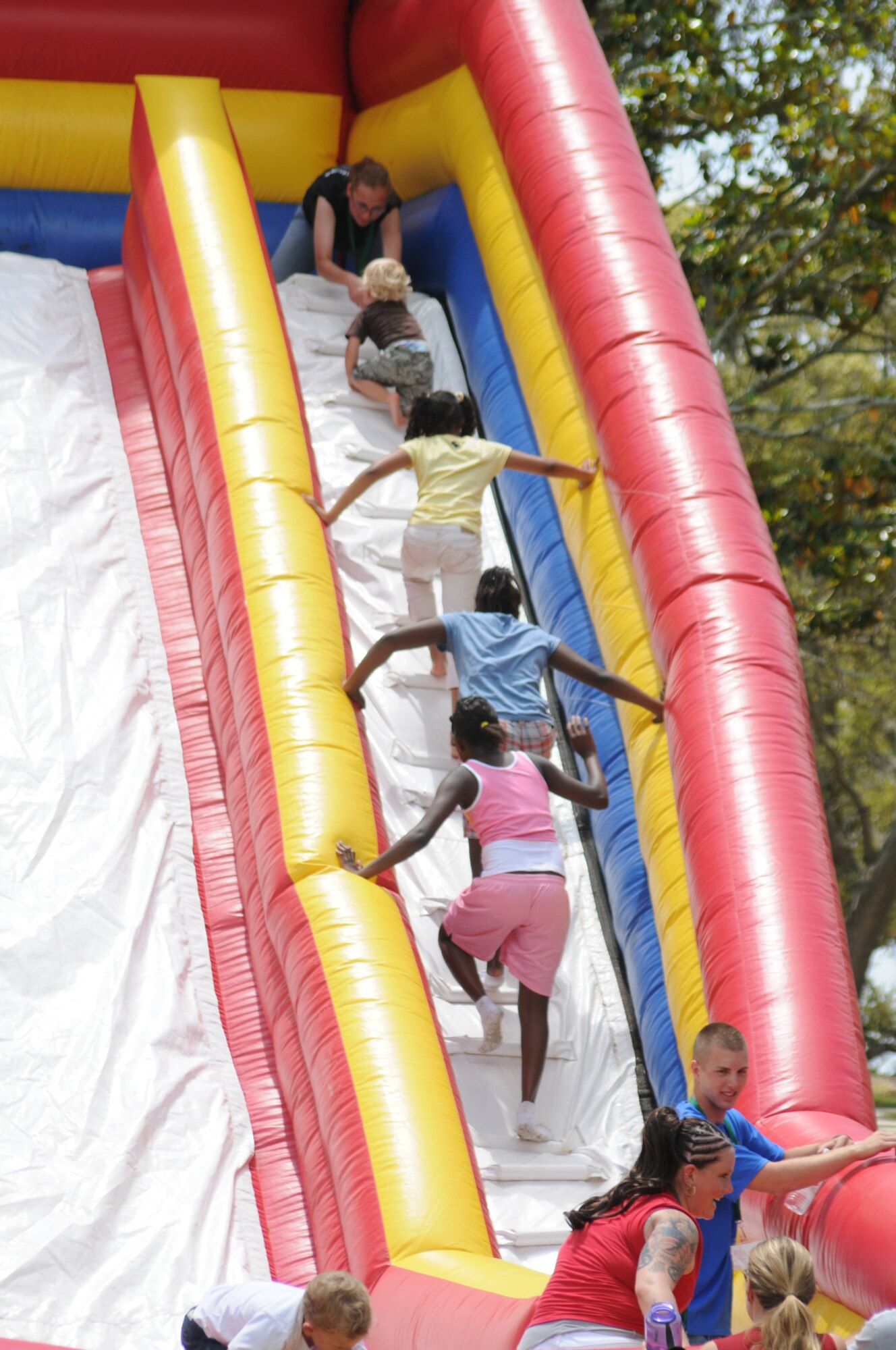 A student volunteers from the 81st Training Group keeps an eye on the children enjoying an inflatable climber in marina park.  (U.S. Air Force hoto by Kemberly Groue)