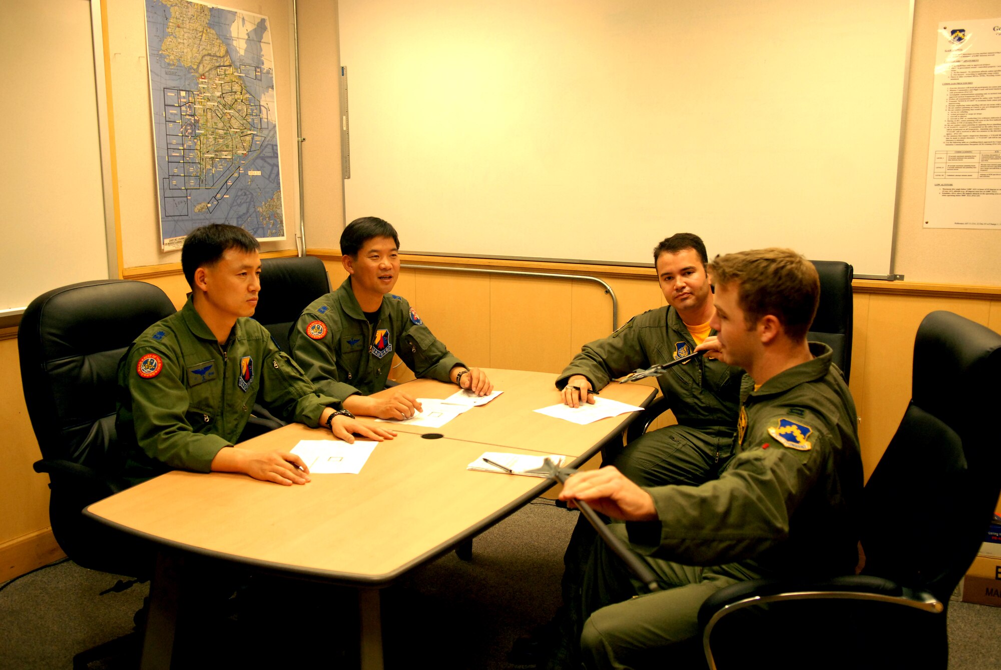 KUNSAN AIR BASE, Republic of Korea -- Republic of Korea Air Force Majors Yoon Chang Bae and Lee Dong Won, 122nd Fighter Squadron F-15K pilots, conduct a pre-flight briefing with U.S Air Force Captains Ryan Lucero and Ben Vickers, 80th Fighter Squadron F-16 pilots, here May 2.  Pilots from Kunsan are assisting ROKAF pilots with the preparation for their upcoming participation in Red Flag at Nellis AFB, Nevada.  (U.S. Air Force photo/Senior Airman Giang Nguyen)        
