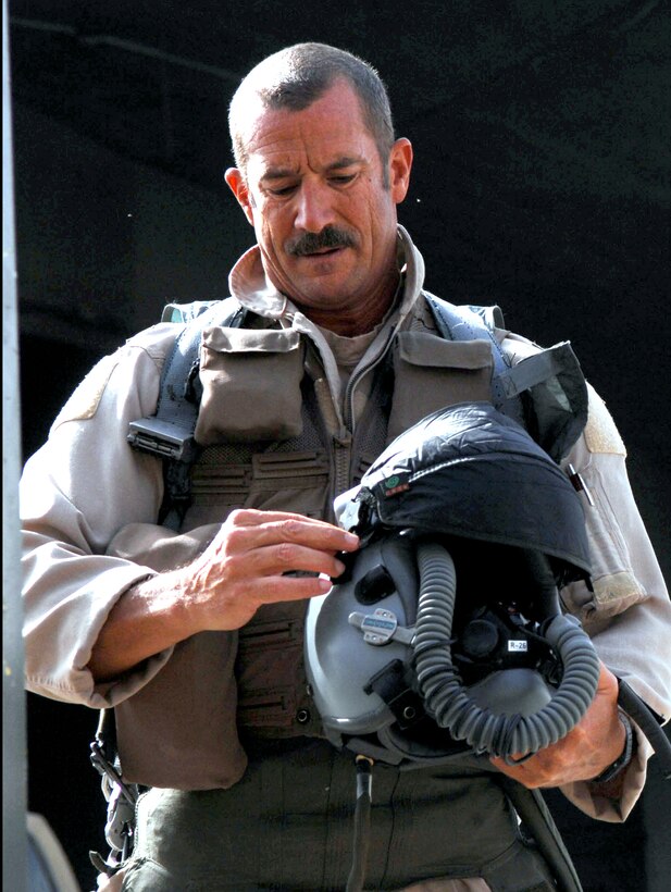 Air Force Reserve Lt. Col. Michael Brill, a 421st Expeditionary Fighter Squadron pilot, prepares to don his helmet at Balad Air Base, Iraq, before flying a combat mission May 2, 2008. Brill broke the world record he previously set for F-16 flying hours when he surpassed the 6,000-hour milestone. Brill is deployed from Hill Air Force Base, Utah. U.S. Air Force photo by Senior Airman Julianne Showalter