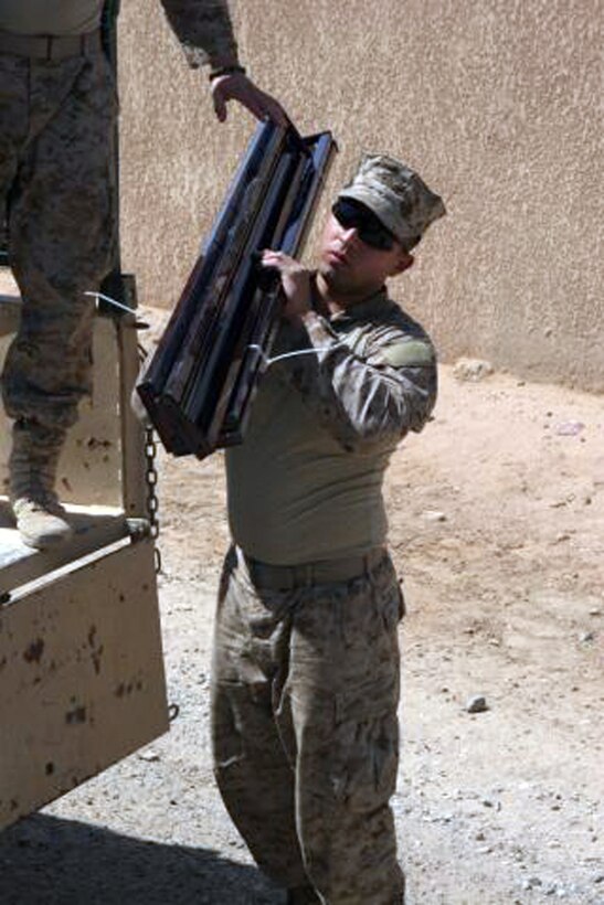 Lance Cpl. Marcos A. Luna, 20, from Mexicali, Mexico, a civil affairs team member, Civil Affairs Team 1, Detachment 1, 2nd Battalion, 11th Marine Regiment, Regimental Combat Team 5, carries a bed frame to the trailers in Barwana, Iraq, May 2. The Barwana Civil Affairs Group was relocated to Haditha as the result of the local government taking over responsibility for the welfare of its people. The team of Marines who worked there will still be able to keep tabs on operations within the town, but will encourage the people to learn to utilize their local government.
