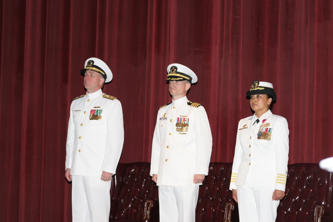 Navy Capt. John B. Burgess (center) assumes command of the Naval Health Clinic at Marine Corps Air Station Cherry Point from Capt. Eleanor Valentin (right) as Navy Rear Adm. Matthew L. Nathan (left), the commander of Navy Medicine East oversees the ceremony.