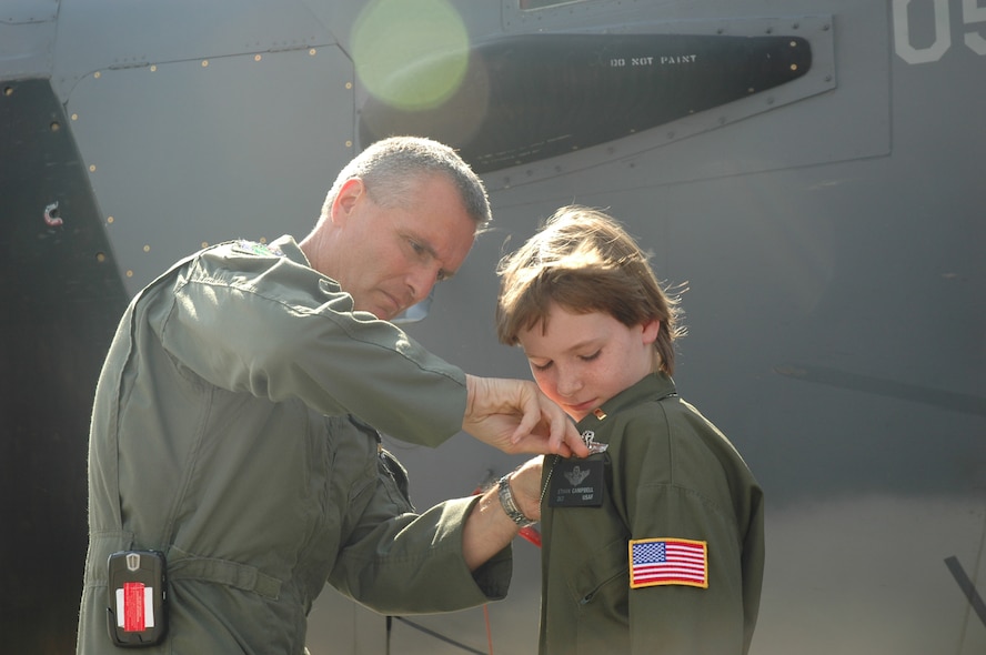 Col. Steven J. Chapman, 919th Special Operations Wing commander, pins on 2nd Lt. Ethan Campbell's pilot's wing shortly after completing a runway taxi on an MC-130E Combat Talon I aircraft during Pilot for a Day at Duke Field May 2. The 10-year-old honorary pilot is diagnosed with leukemia. The Pilot for a Day program gives children with serious health conditions a break from treatments to experience a day in the life of an Air Force pilot. (U.S. Air Force Photo/Jasmine DeNamur)