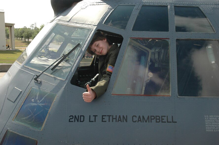 Honorary 2nd Lt. Ethan Campbell gives a thumbs-up after taxiing down the Duke Field runway in an MC-130E Combat Talon I during Pilot for a Day May 2. The 10-year-old honorary pilot is diagnosed with leukemia. The Pilot for a Day program gives children with serious health conditions a break from treatments to experience a day in the life of an Air Force pilot. Lieutenant Campbell was treated to an all-star tour of the Duke Field Fire Department, experienced a simulator ride, battled insurgents with security forces members, and taxied in the wing's aircraft where he was then given his pilot's wings. (U.S. Air Force Photo/Jasmine DeNamur)