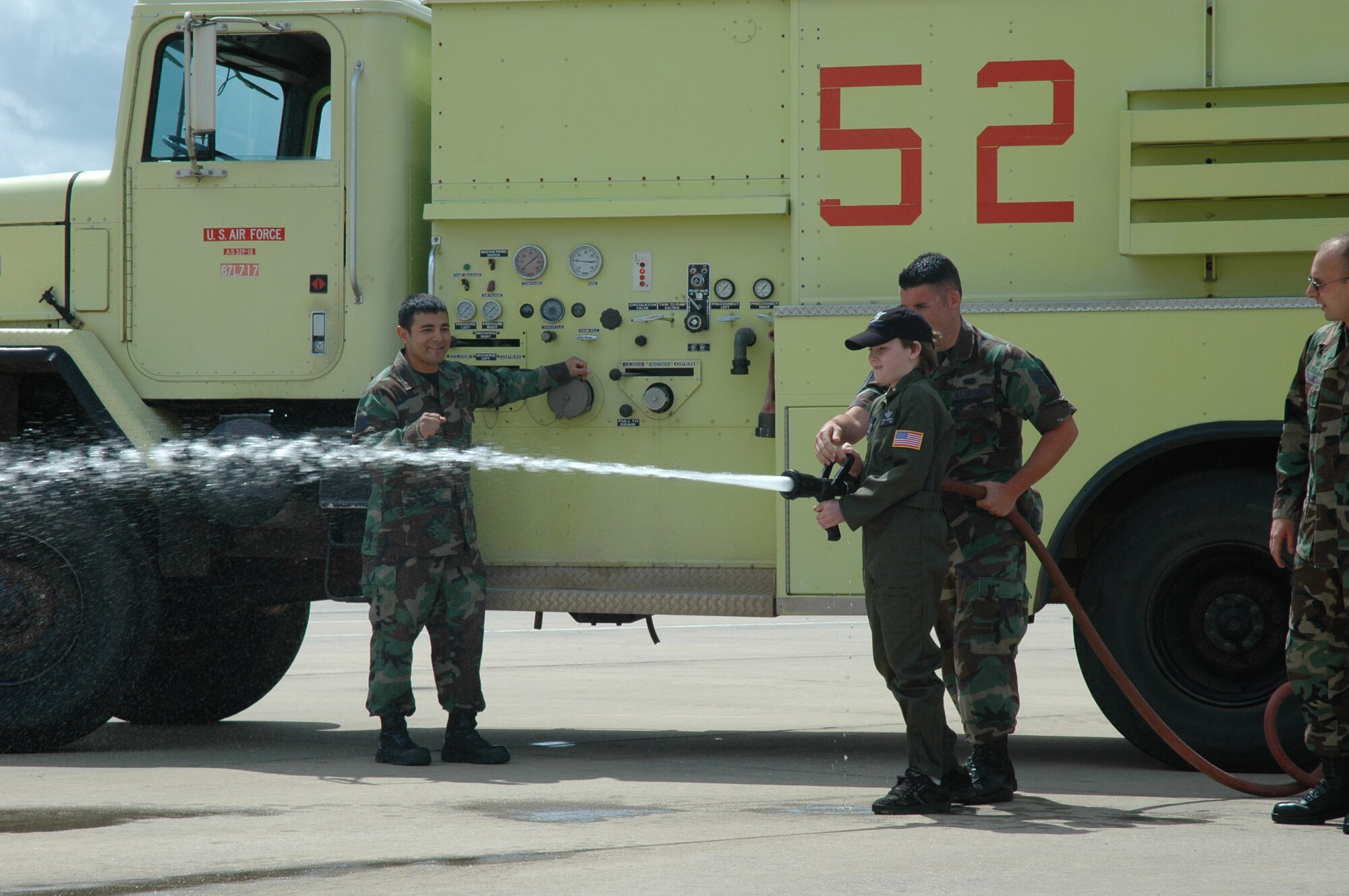 Honorary 2nd Lt. Ethan Campbell blasts caution cones with a fire hose during Pilot for a Day at Duke Field May 2. The Pilot for a Day program gives children with serious health conditions a break from treatments to experience a day in the life of an Air Force pilot. Lieutenant Campbell was treated to an all-star tour of the Duke Field Fire Department, experienced a simulator ride, battled insurgents with security forces members, and taxied down a runway in an MC-130E Combat Talon I aircraft where he was then given his pilot's wings. (U.S. Air Force Photo/Jasmine DeNamur)