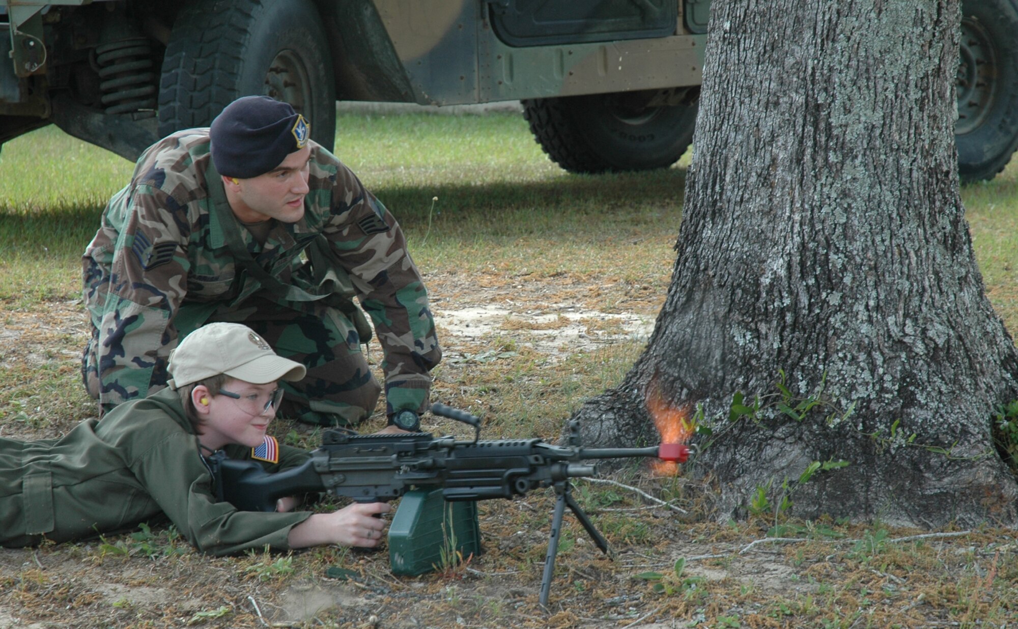 Staff Sgt. James Parrish, 919th Security Force Squadron member, assists 2nd Lt. Ethan Campbell shoot blank fire rounds at "insurgents" during Pilot for a Day at Duke Field May 2. The 10-year-old honorary pilot is diagnosed with leukemia. The Pilot for a Day program gives children with serious health conditions a break from treatments to experience a day in the life of an Air Force pilot. 2nd Lieutenant Campbell was treated to an all-star tour of the Duke Field Fire Department, experienced a simulator ride, battled insurgents with security forces members, and taxied in the wing's aircraft where he was then given his pilot's wings. (U.S. Air Force Photo/Jasmine DeNamur)