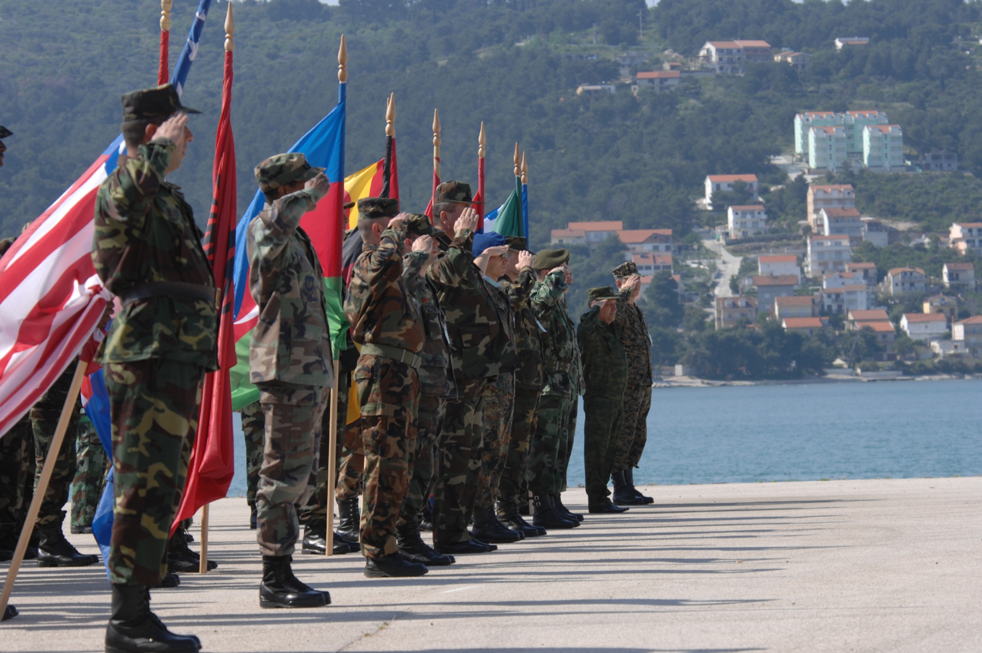 DIVULJE TRAINING BASE, Croatia – Several nations salute during the U.S. and Croatian National anthems to commemorate the opening ceremony of the 2008 Medical Training Exercise in Central and Eastern Europe (MEDCEUR).  Fifteen nations are participating in the exercise from May 2 through 14. The exercise focuses on mass-casualty training scenarios and humanitarian aid in response to crises situations. More than 400 multi-nationals are attending the exercise in support of the Partnership for Peace initiative. (U.S. Air Force photo/Staff Sgt. Kristin Ruleau)