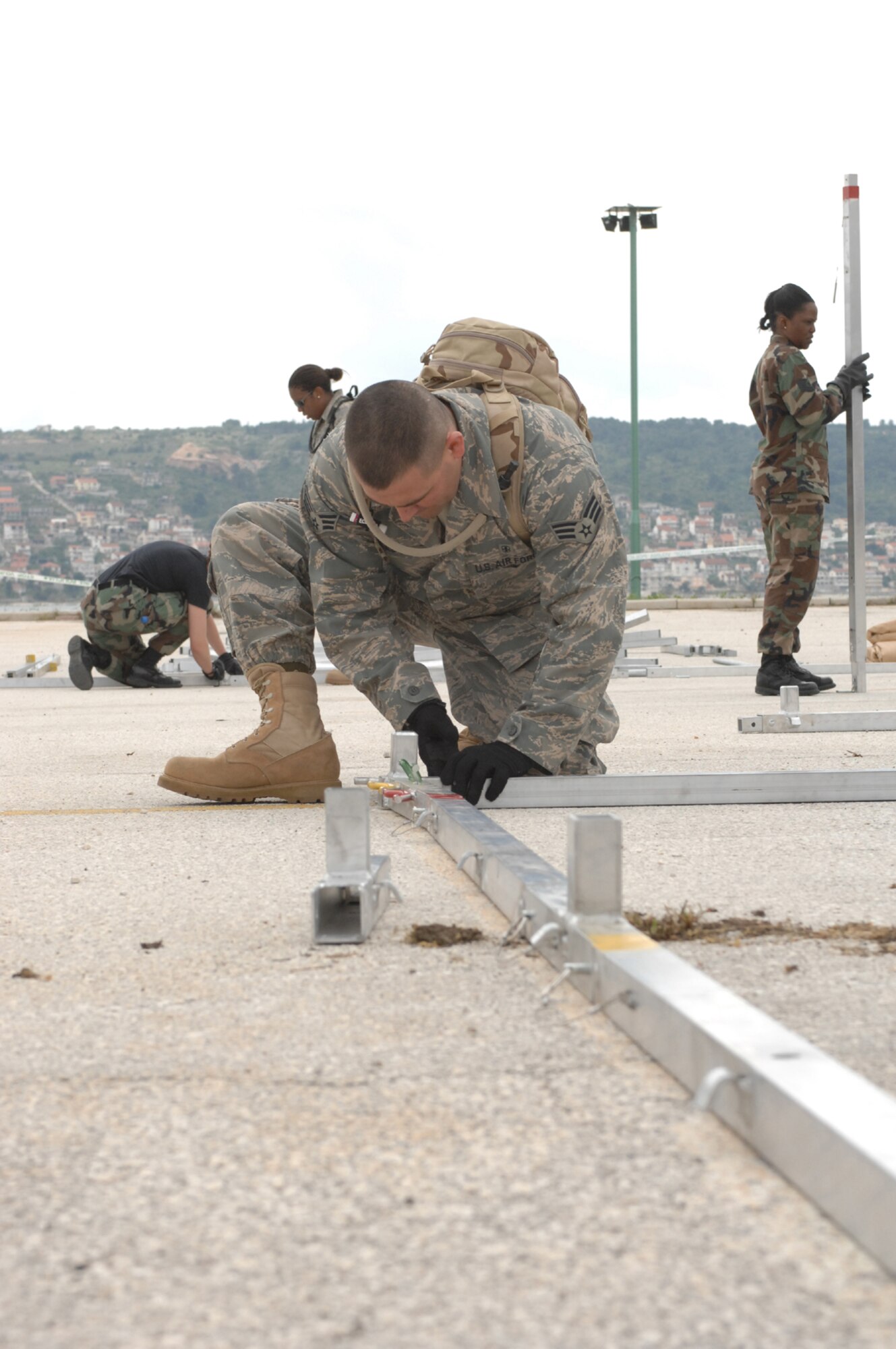 DIVULJE TRAINING BASE, Croatia – U.S. Air Force Senior Airman Tim Raso, 52nd Medical Operations Squadron, learns how to assemble a tent frame April 30.  The tents are Expeditionary Medical Squadron (EMEDS) +10 tents designed to provide patient care for ten or more people as a mobile field hospital.  Raso is deployed from Spangdahlem Air Base, Germany, for the 2008 Medical Training Exercise in Central and Eastern Europe (MEDCEUR).  Fifteen nations are participating in the exercise from May 2 through 14. The exercise focuses on mass-casualty training scenarios and humanitarian aid in response to crises situations. More than 400 multi-nationals are attending the exercise in support of the Partnership for Peace initiative. (U.S. Air Force photo/Staff Sgt. Kristin Ruleau) 