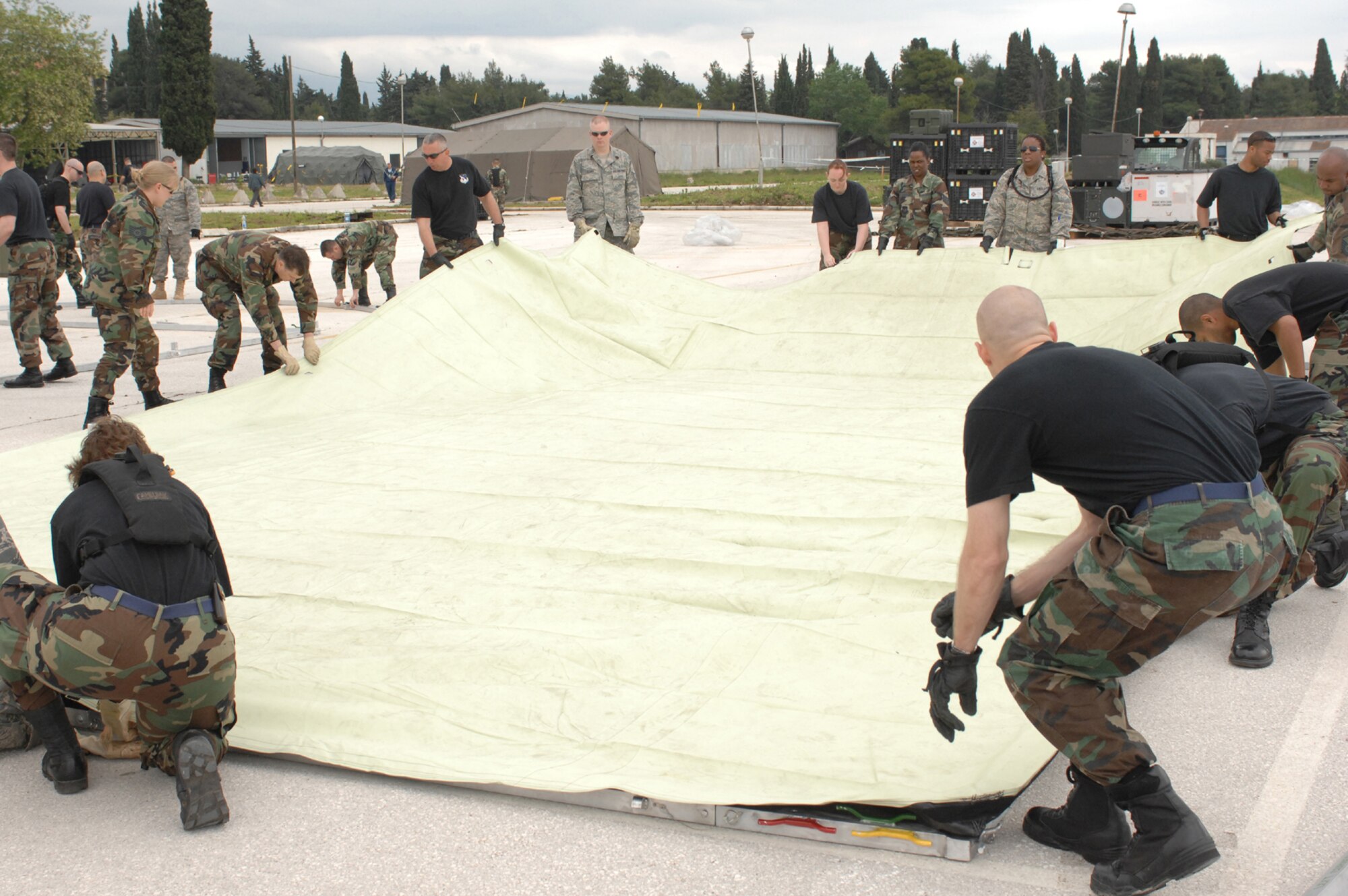 DIVULJE TRAINING BASE, Croatia – U.S. Air Force medical personnel join together to learn how to assemble tents April 30.  The tents are Expeditionary Medical Squadron (EMEDS) +10 tents designed to provide patient care for ten or more people as a mobile field hospital.  Members of this team are deployed from Spangdahlem Air Base, Ramstein Air Base and Landstuhl Regional Medical Center, all in Germany, for the 2008 Medical Training Exercise in Central and Eastern Europe (MEDCEUR).  Fifteen nations are participating in the exercise from May 2 through 14. The exercise focuses on mass-casualty training scenarios and humanitarian aid in response to crises situations. More than 400 multi-nationals are attending the exercise in support of the Partnership for Peace initiative. (U.S. Air Force photo/Staff Sgt. Kristin Ruleau) 