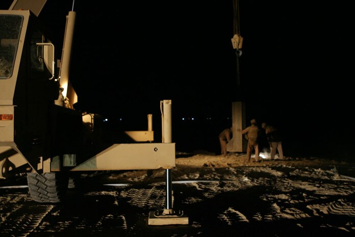 Marines with Support Platoon, 3rd Combat Engineer Battalion, Regimental Combat Team 5, work to place a "Texas" barrier, which is a concrete protective barrier, into position at a new traffic control point in Baghdadi, Iraq May 4. The engineers have been working 24-hour shifts to complete this project for the Iraqi Army. Members of the IA currently occupy a school house which is scheduled to be renovated and turned back over to the Baghdadi residents in August, one month prior to the new school year.