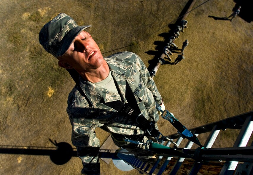 Leaning back while 40 feet up a pole, Airman Basic Cody Seymour has to trust his harness to pass this acrophobia test at Lackland AFB, Texas. (photo by Tech. Sgt. Matthew Hannen)