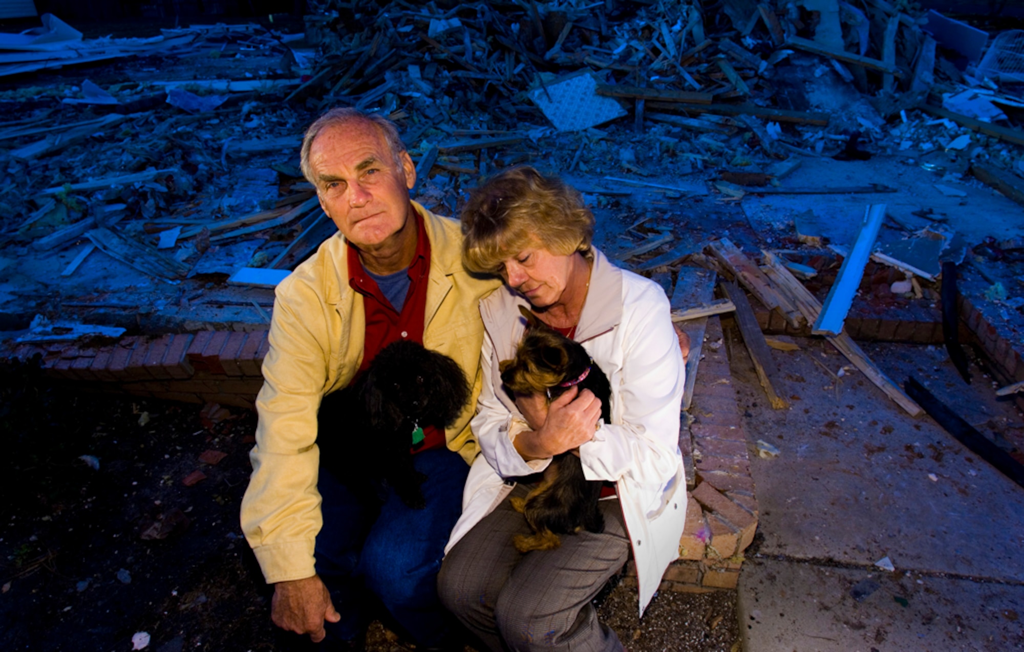 With their dream home reduced to a nightmarish rubble, Wayne and Ilah Glover, with their dogs Bailey and Izzie, say they will rebuild, a process that could take up to nine months. (Photo by Tech. Sgt Matthew Hannen)