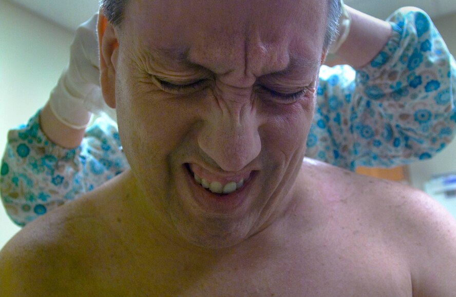 Forkner winces while getting his injuries cleaned and bandaged by Lucy Mara, a registered nurse at the Wound Care Center at Baptist Medical Center South in Montgomery, Ala. (Photo by Tech. Sgt Matthew Hannen)