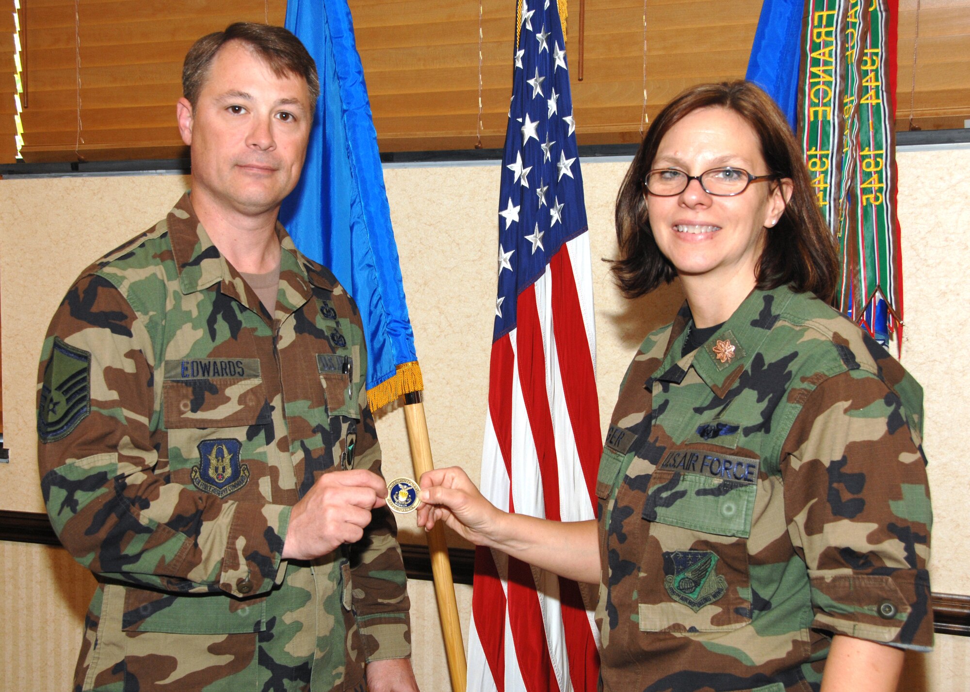 SEYMOUR JOHNSON AIR FORCE BASE, N.C. -- Chaplain Carol Yeager presents the first 916th Chaplain's Coin to Senior Master Sgt. Tim Edwards. Sgt. Edwards was instrumental in helping the 916th chaplain's office achieve numerous successes over the past several years before transferring to the 22nd Air Force Safety Office. The coin shows the state of North Carolina with a lighthouse clearly pointing to Seymour Johnson and the KC-135R Stratotanker. U.S. Air Force photo/TSgt. Gillian Albro