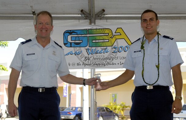 Lt. Col. Stephen Shrewsbury (left) and Capt. Benjamin Beliles, both from the 36th Wing Judge Advocate’s Office, accept the inaugural Husticia Award on behalf of their office during a Law Week celebration May 3 at Agana Shopping Center. The Husticia Award is given to organizations that have made outstanding law contributions to the community. (U.S. Air Force photo by Staff Sgt. Patrick Mitchell)