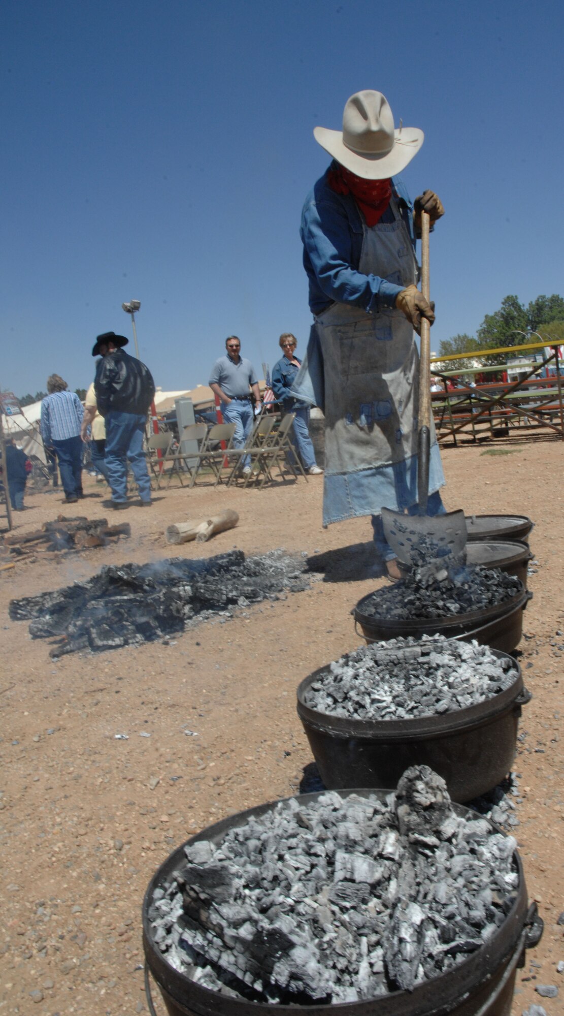 CANNON AIR FORCE BASE, N.M.-- Paul Geeslin, Odessa, Texas, places charcoal on Dutch ovens for the Clovis Chuck Wagon Cook Off May 3. The Cook Off took place at Curry County Fairgrounds in Clovis, N.M. (U.S. Air Force photo/Airman 1st Class Evelyn Chavez)  