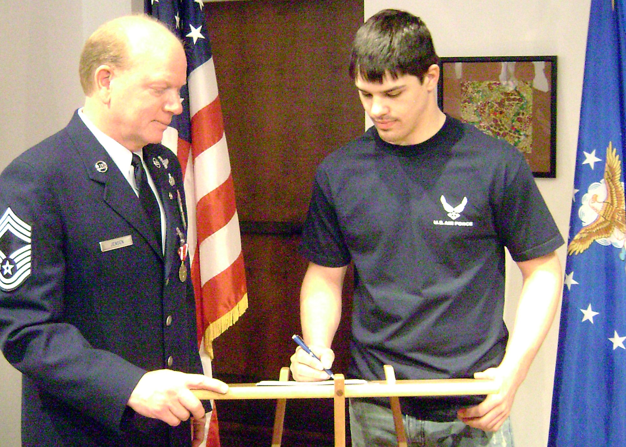 Chief Master Sgt. Kurt Jensen, Air Force Reserve, assists Lee Vancleef from Kendall, Wisc., to join the Air Force in Lacrosse, Wisc., May 1. The former active-duty Air Force survival, evasion, resistance and escape specialist retired from 30 years of Air Force service the same day he helped the 937th person join. (U.S. Air Force photo/Master Sgt. Laurence Lewis)