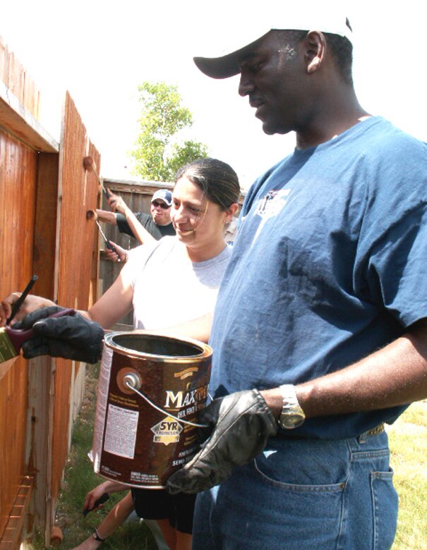 Tech. Sgt. Becca Dahl (left) and Master Sgt. Ken Pittman (right), personnelists at the Air Force Personnel Center, Randolph Air Force Base, Texas, apply waterproofing to a fence as part of a volunteer effort supporting Operation Homefront. Volunteers from AFPC's Junior Enlisted Council and Top 3 Association helped stain fencing and built a gate to provide better access between the front and back yards for Tech. Sgt. Israel Del Toro, an Airman recovering from wounds sustained during a roadside bombing in Afghanistan, December 2005. (US Air Force photo/Master Sgt. Kat Bailey) 