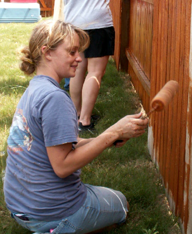 Staff Sgt. Sara Digennaro, a personnelist at the Air Force Personnel Center, Randolph Air Force Base, Texas, applies waterproofing to a fence as part of a volunteer effort supporting Operation Homefront. Volunteers from AFPC's Junior Enlisted Council helped stain fencing and craft a gate to provide better access between the front and back yards for Tech. Sgt. Israel Del Toro, an Airman recovering from wounds sustained during a roadside bombing in Afghanistan, December 2005. (US Air Force photo/Master Sgt. Kat Bailey) 